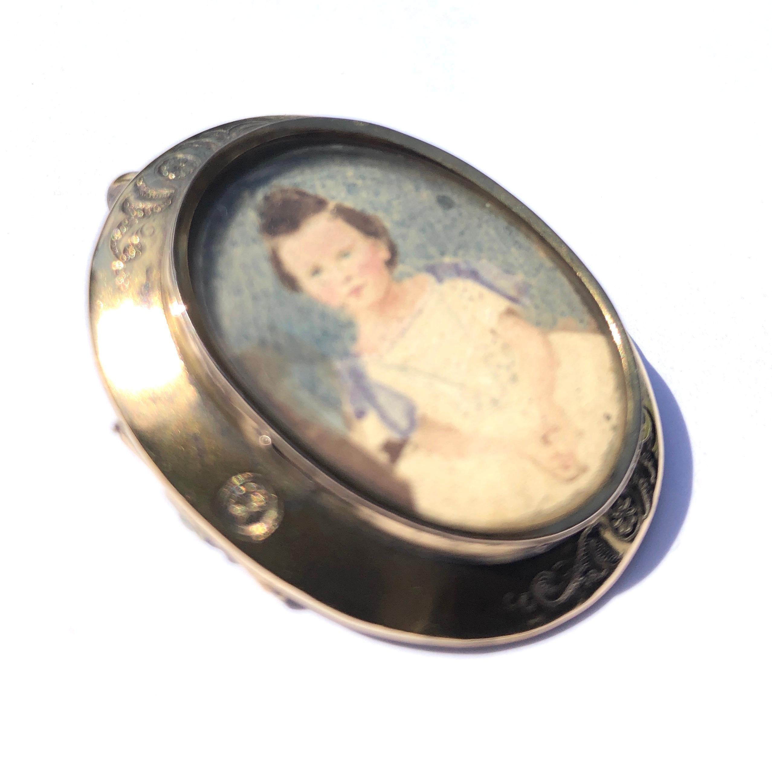 This gorgeous piece has fine intricate flower and swirl engraving and holds a picture of a lovely little girl smartly dressed in her finery. This could be either a pendant or a brooch.

Dimensions: 37x32mm

Weight: 9.49g