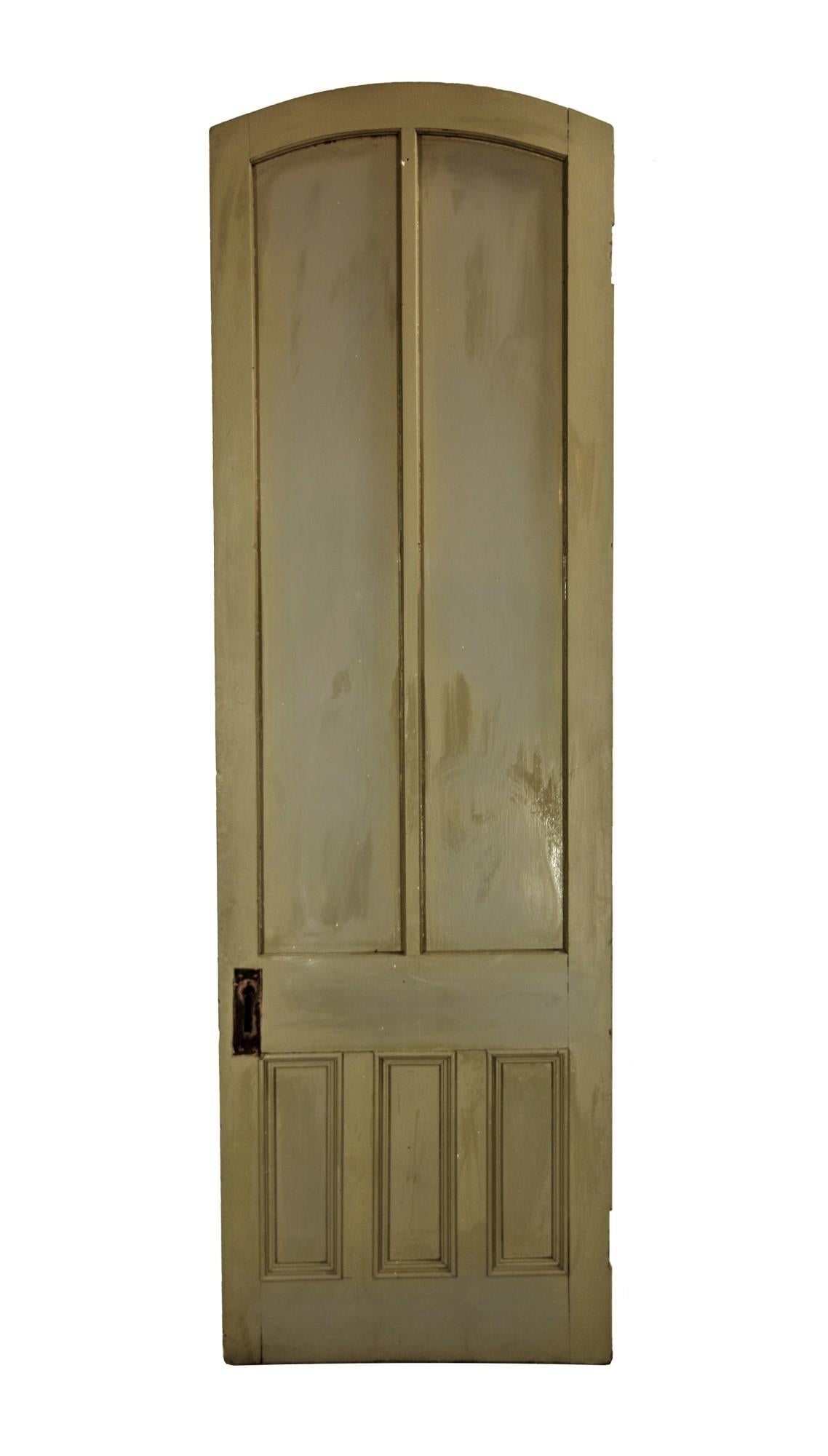 Late 19th century antique tall gray painted pine arched door with five vertical panels. The panels and trim are two tone on one side. This can be seen at our 400 Gilligan St location in Scranton, PA. Measures: Tall 100.5 x 31.5.