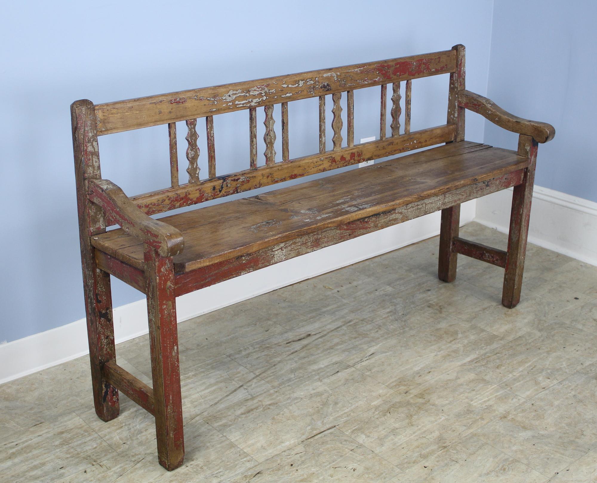 A dainty low hall bench with whimsical traces of the original paint. The perfect perch to put on your boots, or would be right at the end of the bed. Sturdy and nicely proportioned.