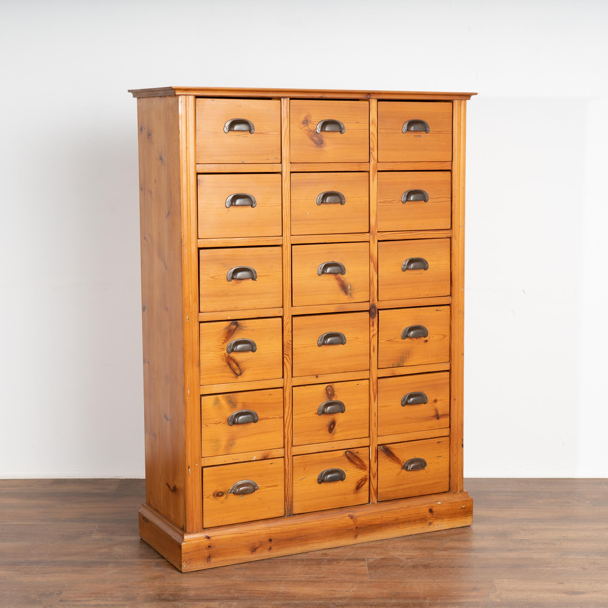 This tall pine apothecary chest of 18 drawers likely served in a Danish country store during the mid to late 1800's. 
The 18 drawers with metal pull handles will serve well to organize and store items for a craft room or workshop.
Restored with a