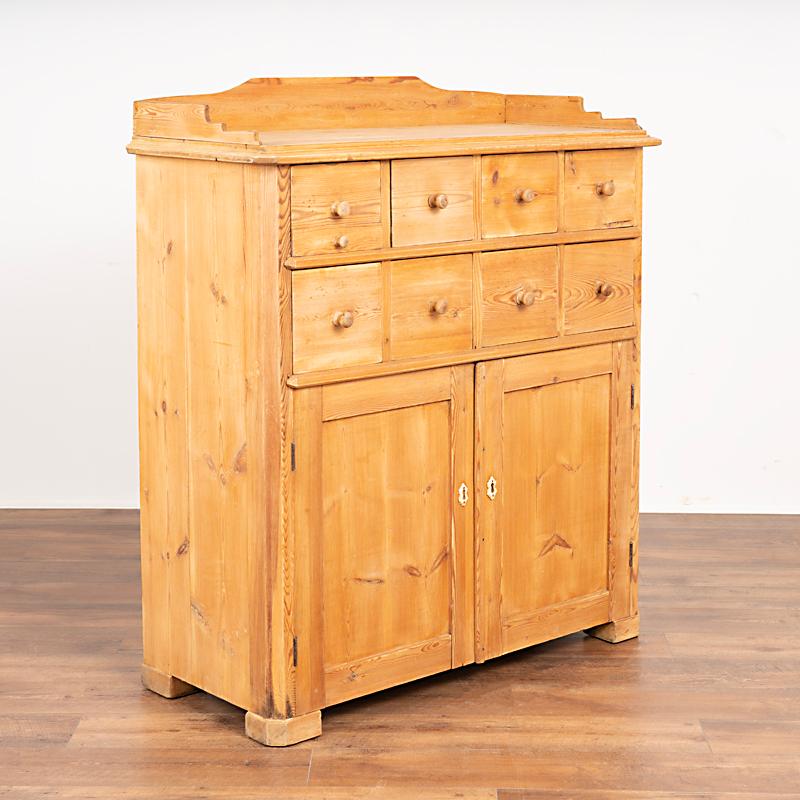 This lovely pine sideboard is unique for several reasons. The eight apothecary upper drawers over two cabinet doors is an interesting configuration, as is the slightly taller height of 45 inches to the top surface (50