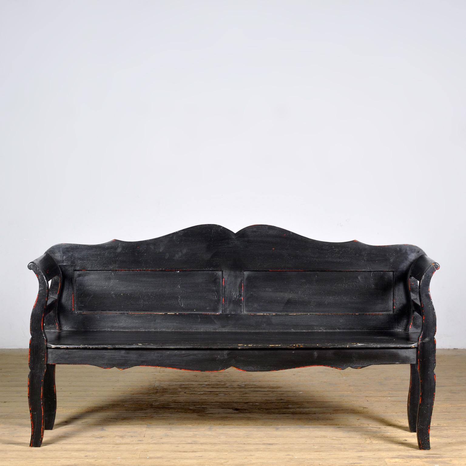 Un charmant banc de Hongrie. Le banc a été fabriqué vers 1900. Avec le temps et l'usage, la peinture noire s'est usée par endroits pour laisser place à une couche de peinture rouge. Exempt de xylophages.