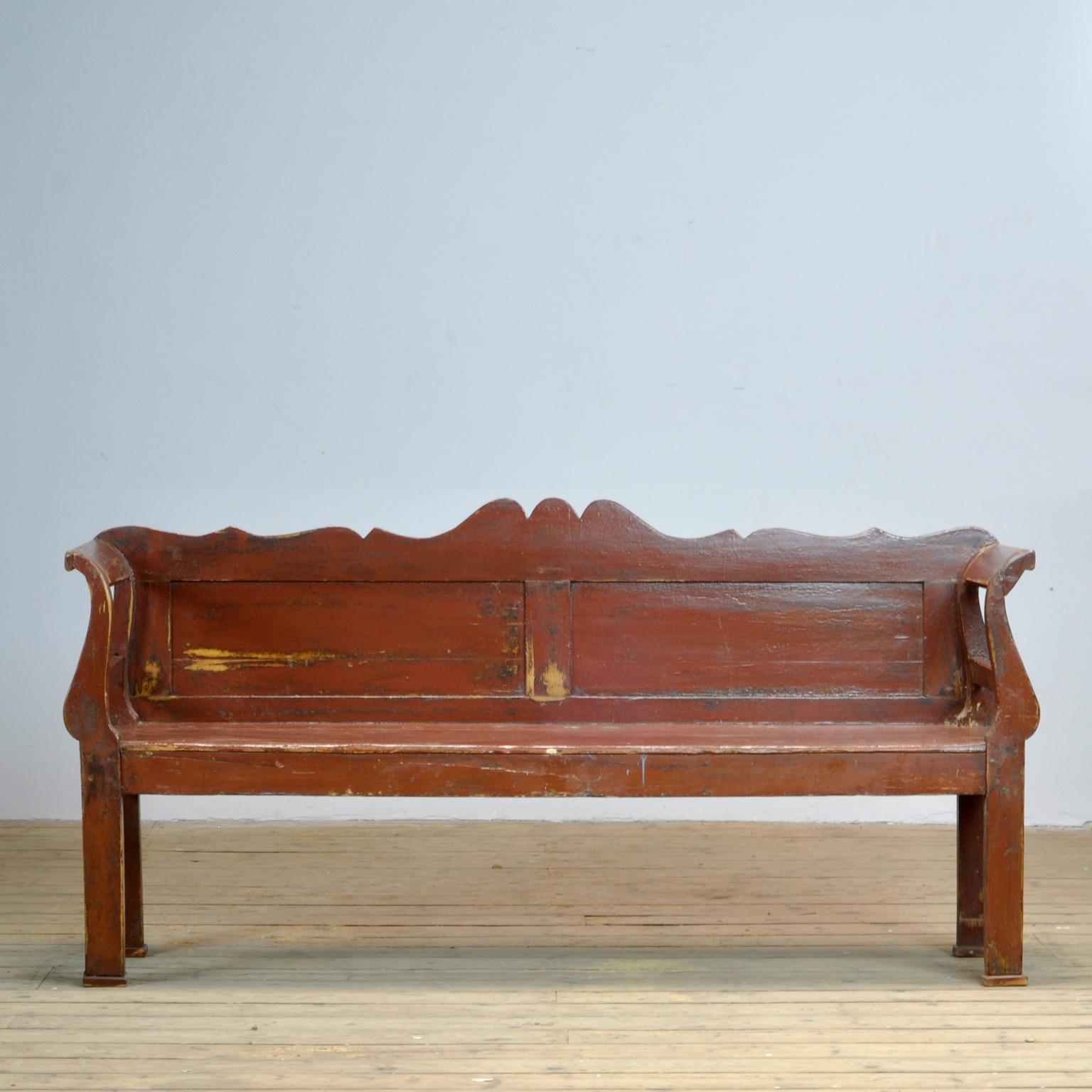A charming bench from Hungary with the original red paint. Over time and use, the paint has been worn away to the wood in some spots. The bench is stable and sturdy.