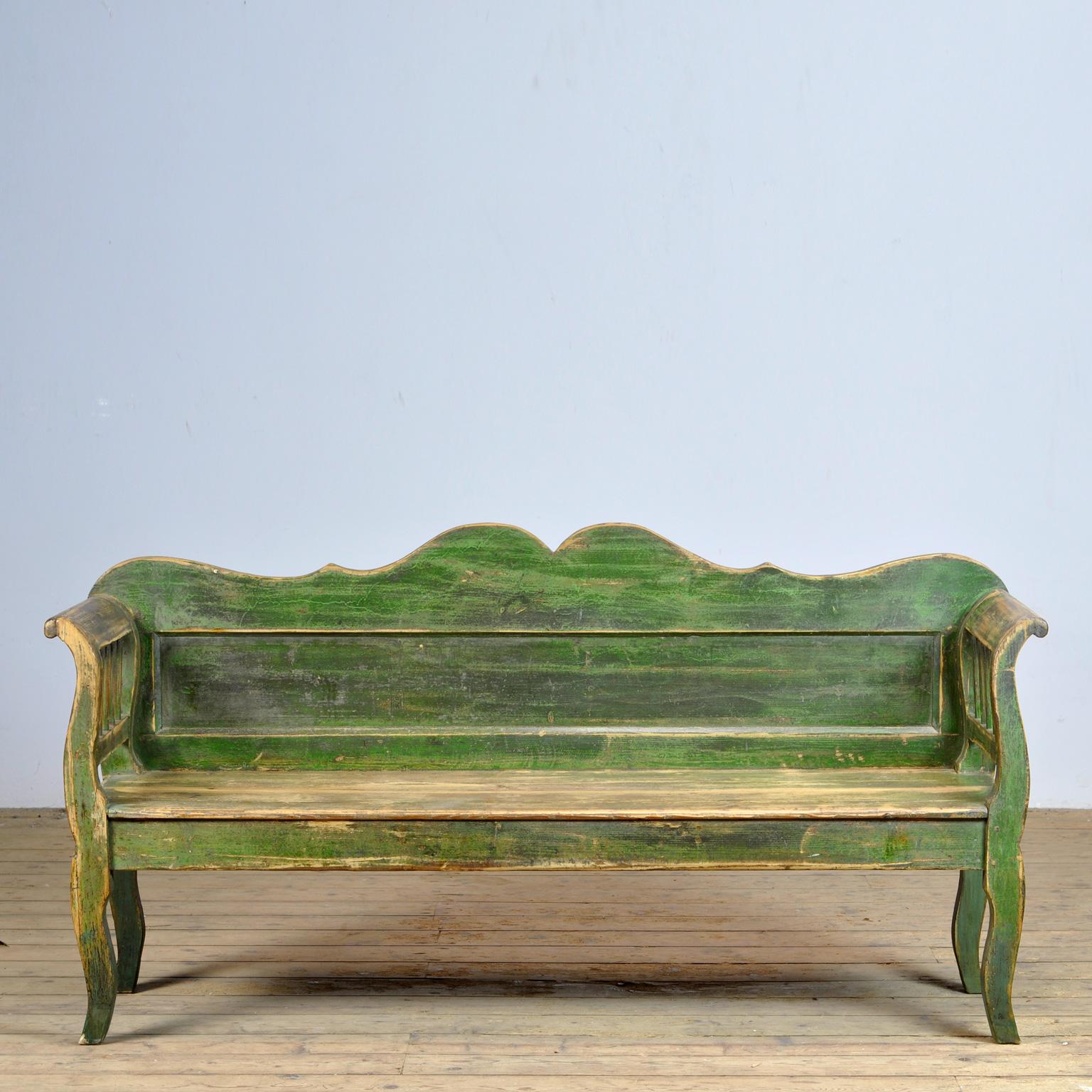A charming bench from Hungary with the original paint. Over time and use, the green paint has been worn away in places to the wood. The bench is stable and sturdy. Free of woodworm.