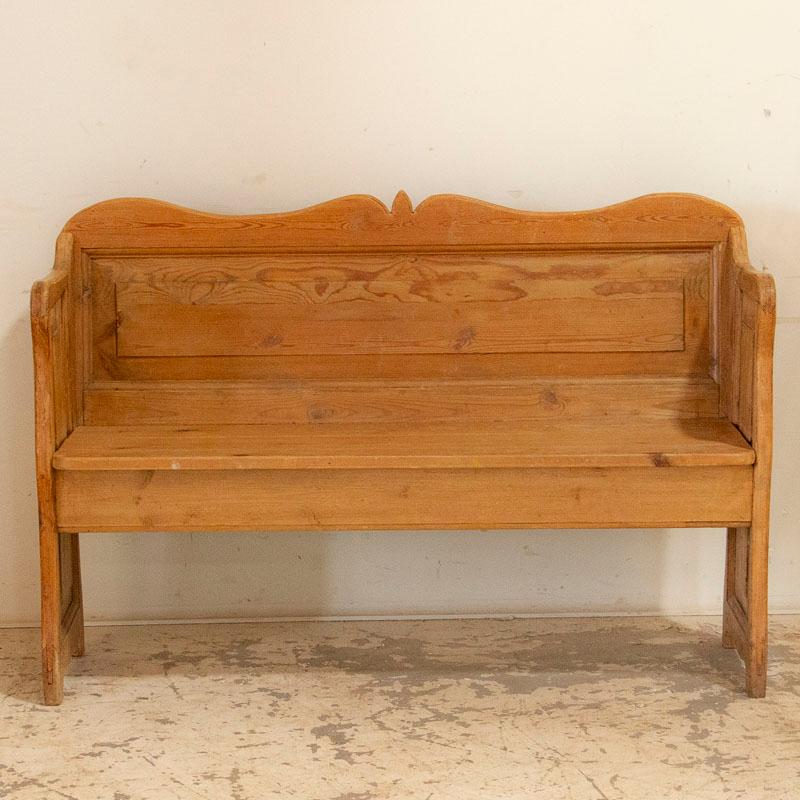 It is the warm patina of the aged pine that draws one to this pleasant bench from Sweden's countryside. Notice the simple panels along the back and sides, while gentle curves accent the top and feet. It is small in scale compared to most benches of