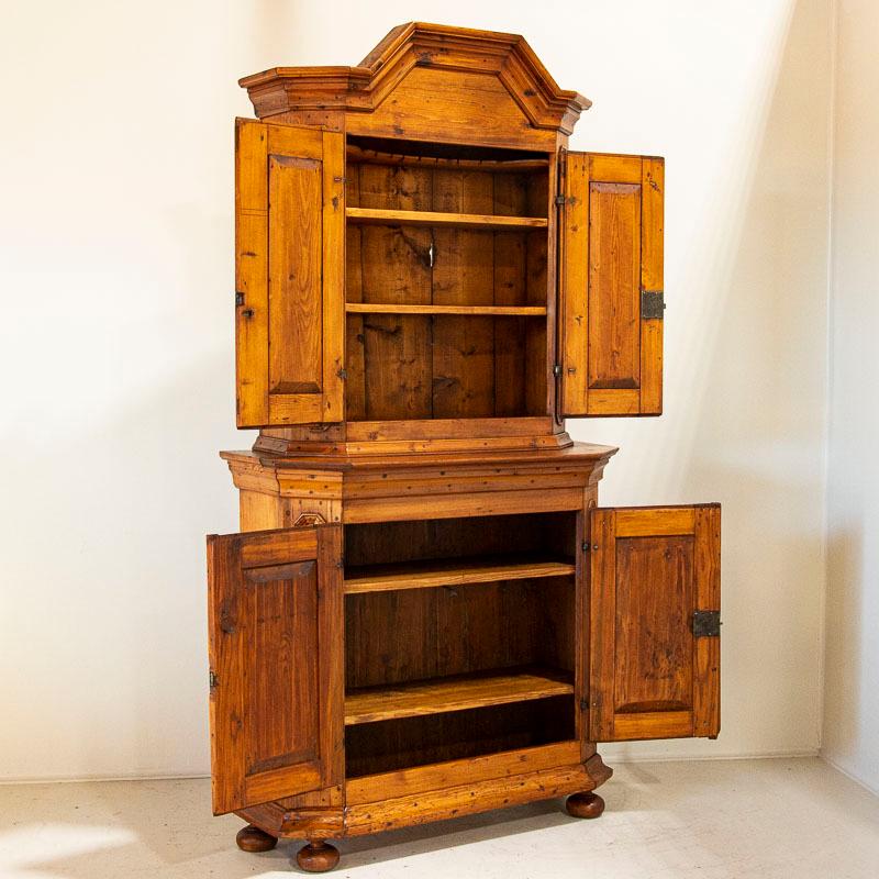 The gentle beauty of this Swedish cupboard is found in the deep patina of the aged pine, dated to 1820-1840 (notice the original hinges). Paneling in the cabinet doors, canted sides and crown molding add depth and character. Any minor cracks,