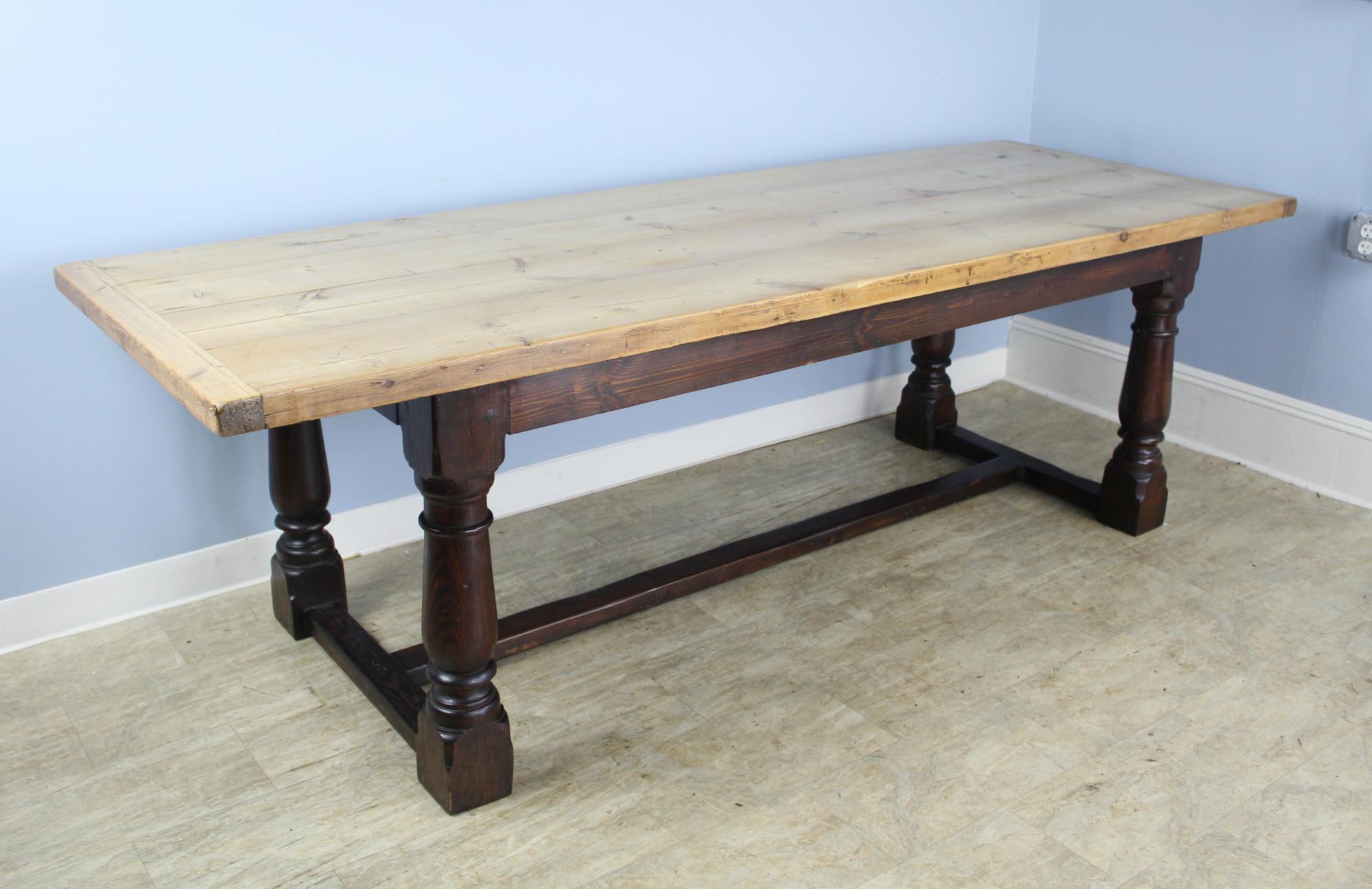 A dramatic dining table with a bleached thick pine top and a painted black refectory base. Large eye catching turned legs under a chunky butcher block top. Glamorous! With 63.25 inches between the legs, this table can accommodate 8. Measures: 24.25