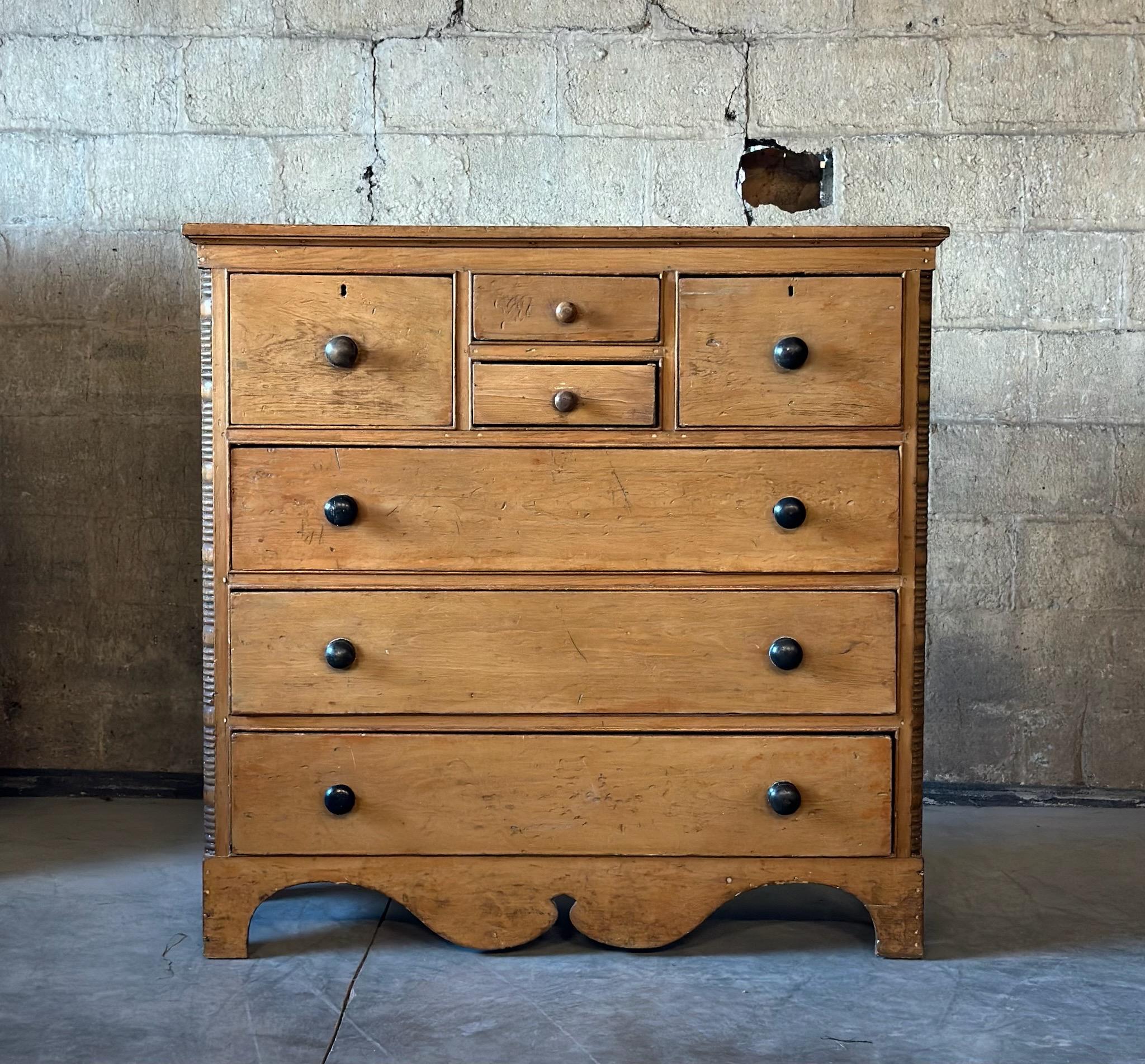 Un comò antico con una bella patina e un'ottima età. Realizzato in pino massiccio con cassetti profondi e grandi dimensioni. Le modanature in legno intagliato gli conferiscono ulteriore carattere.