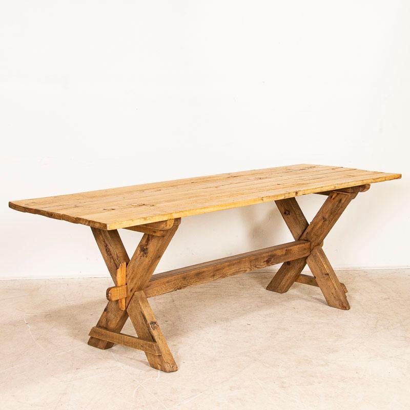 This farmhouse dining table has European country charm thanks to the unique X-stretcher base. The natural pine has been distressed through generations of use, adding depth to the character of the table. The many scratches, dings, gouges, and age