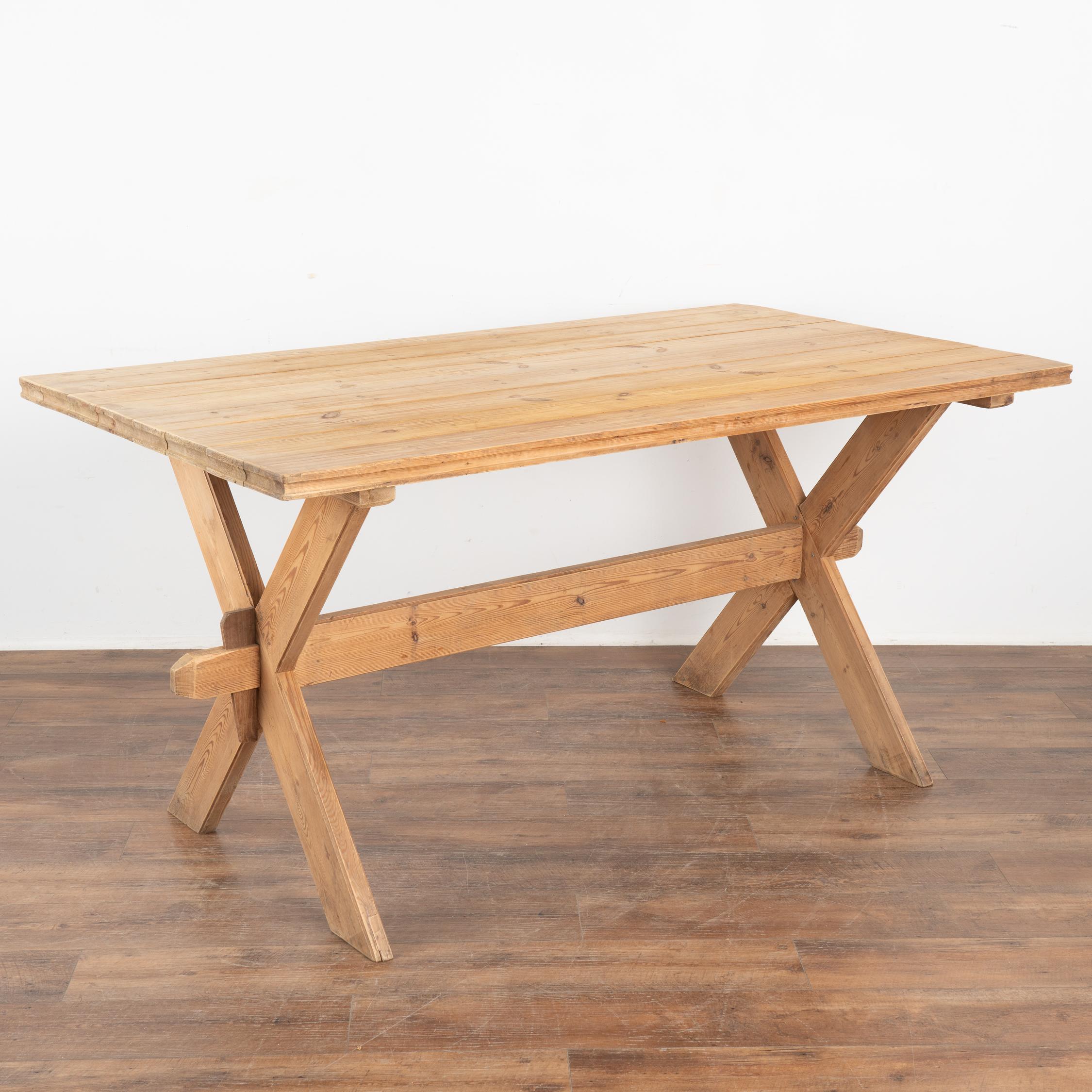 This farmhouse kitchen or dining table has European country charm thanks to the unique X-stretcher base.
The natural pine has been distressed through generations of use, adding depth to the character of the table. The many scratches, dings, stains