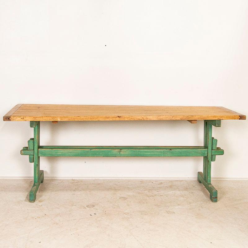 It is the original distressed green paint that captures ones eye in this traditional country farm table with trestle base. The top is made of 6 planks with gouges, marks, stains and knots that all add character and appeal while revealing the years