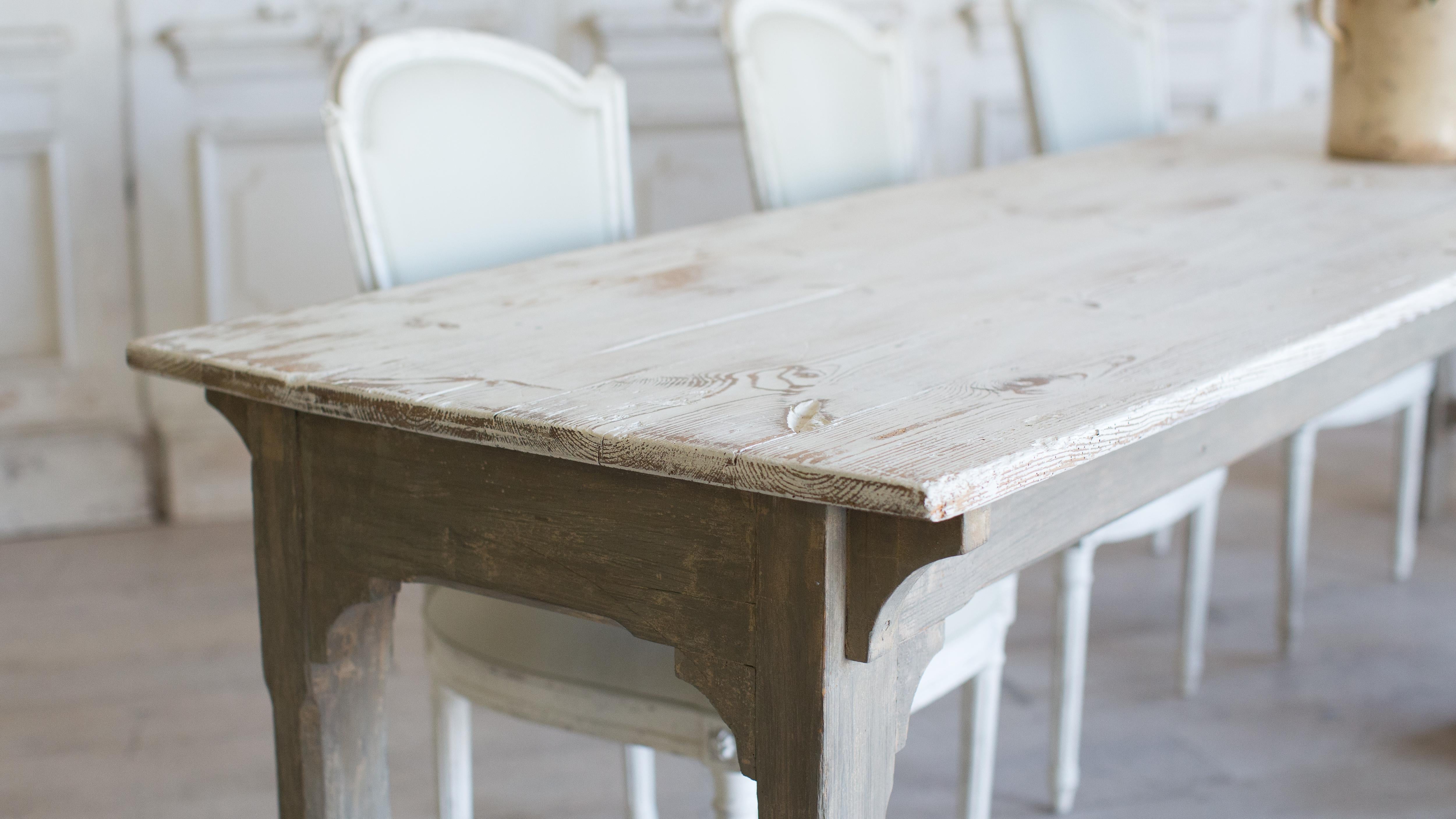 Stylish antique French Provincial farm table in pine. The sturdy base is painted an earthy olive while the top is a worn white that is fresh and fun. The clean arch detailing adds a sophistication to the table.