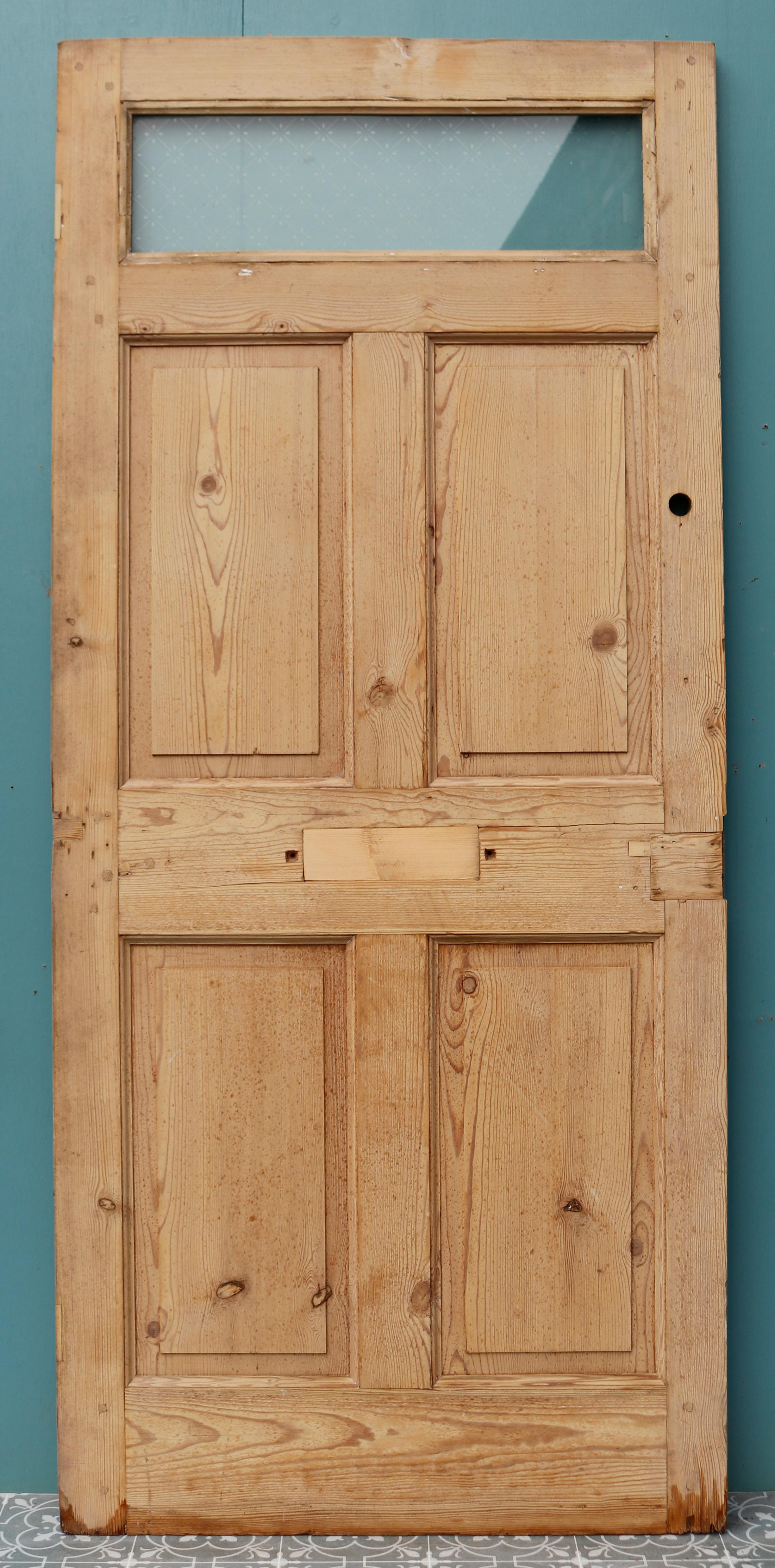 A reclaimed pine door with a clear etched glazed panel at the top.