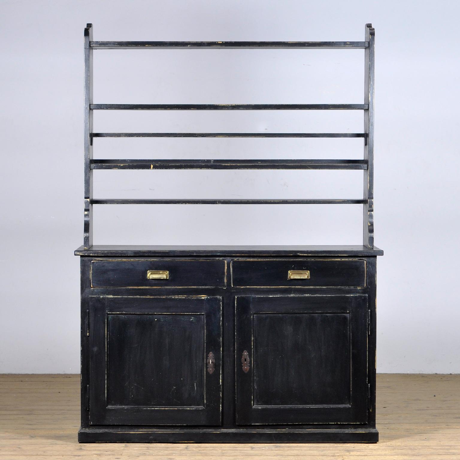 Das Sideboard aus Kiefernholz aus dem 20. Jahrhundert ist ein charmantes Möbelstück aus Kiefernholz mit rustikalem Aussehen. Der Schrank besteht aus zwei separaten Teilen.
Besonders hervorzuheben ist das Tellerregal, das einen speziellen Platz für