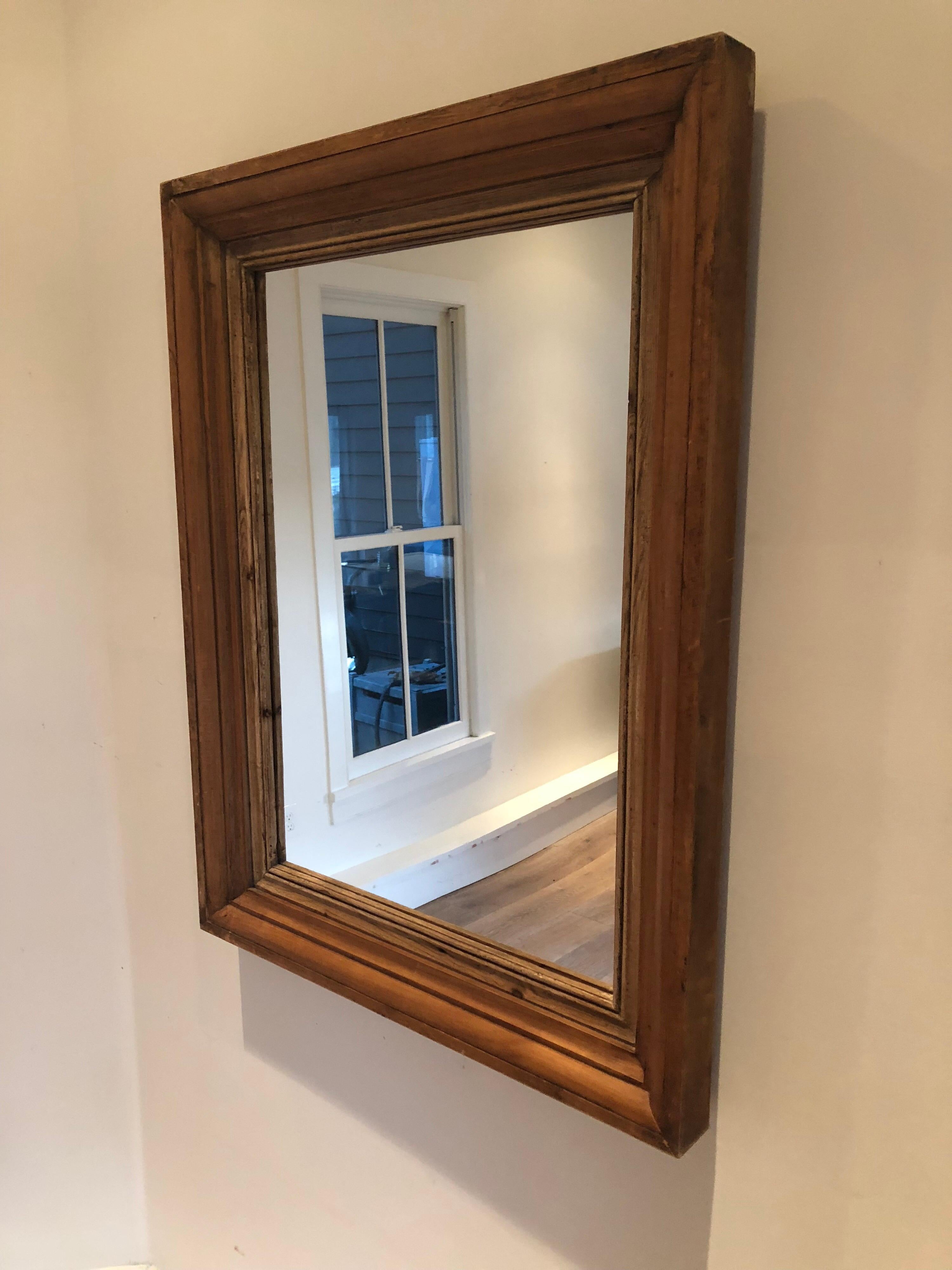 A large antique pine mirror with stacked carved frame.