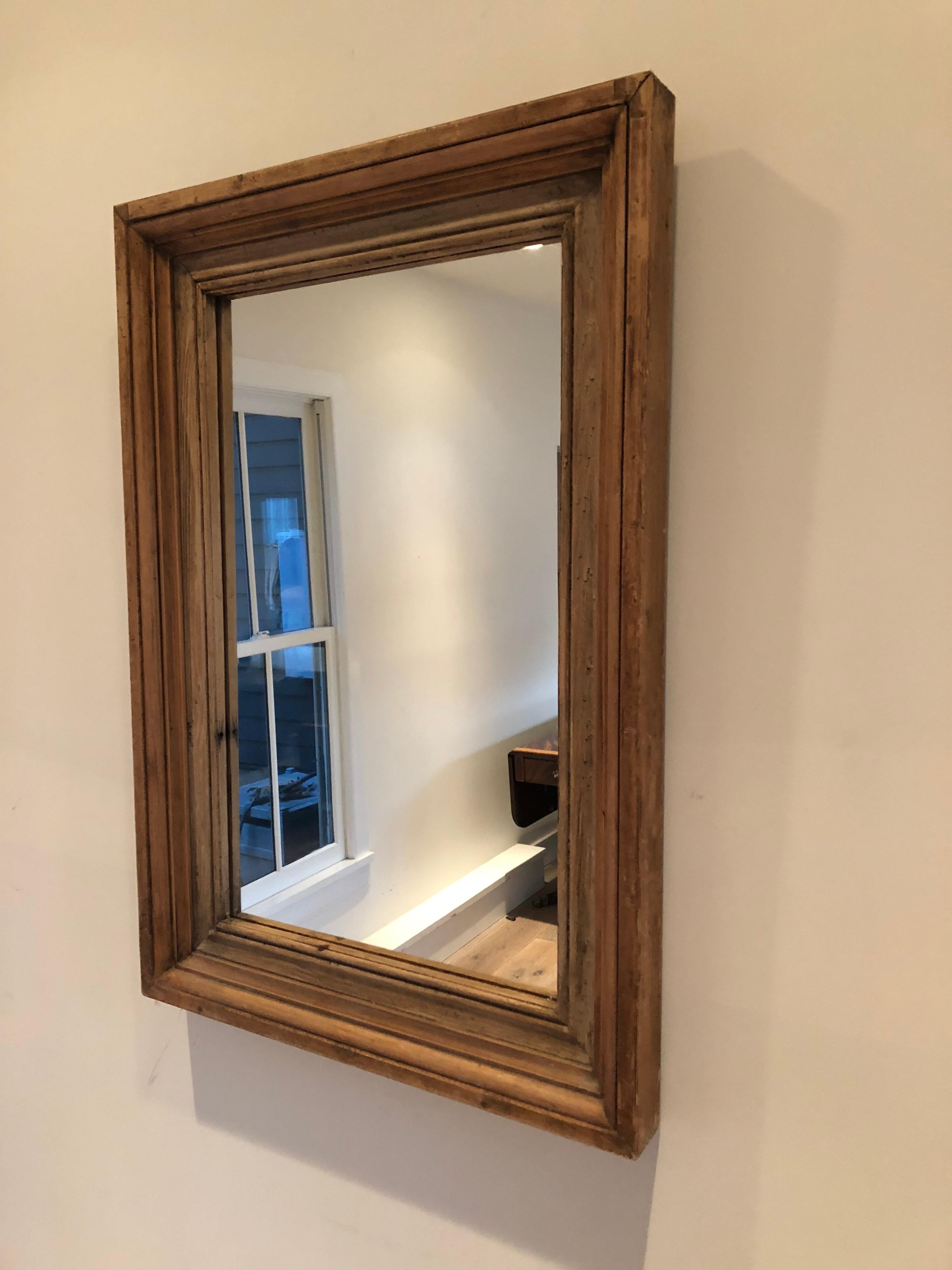 An antique rectangular pine mirror with graduated depth frame.