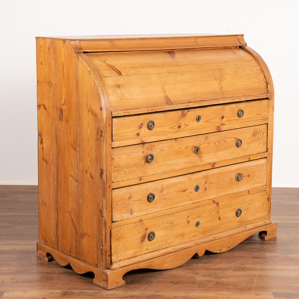 Lovely pine roll top desk or bureau from Sweden from the 1800's.
The age of this secretary is revealed in the warmth of the deep patina in the pine which only happens through generations of use. 
The roll top opens and the top 