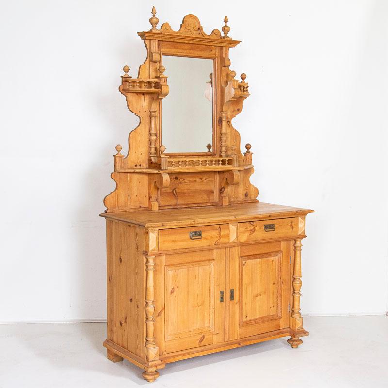 Dieses auffällige Buffet aus Kiefernholz aus den späten 1800er Jahren ist reich an dekorativen Elementen. Gedrechselte Säulen, Endstücke und ein Spiegel tragen zur starken optischen Wirkung bei. Der obere Teil verfügt über stilisierte Regale, um die