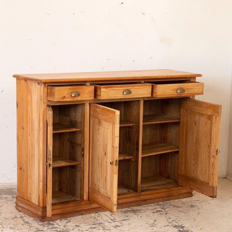 While pine sideboards such as this were a traditional element in a European country home in the 1800s, this one is special because of the extended length. Most sideboards of the era had two doors while this one has three giving it more versatility