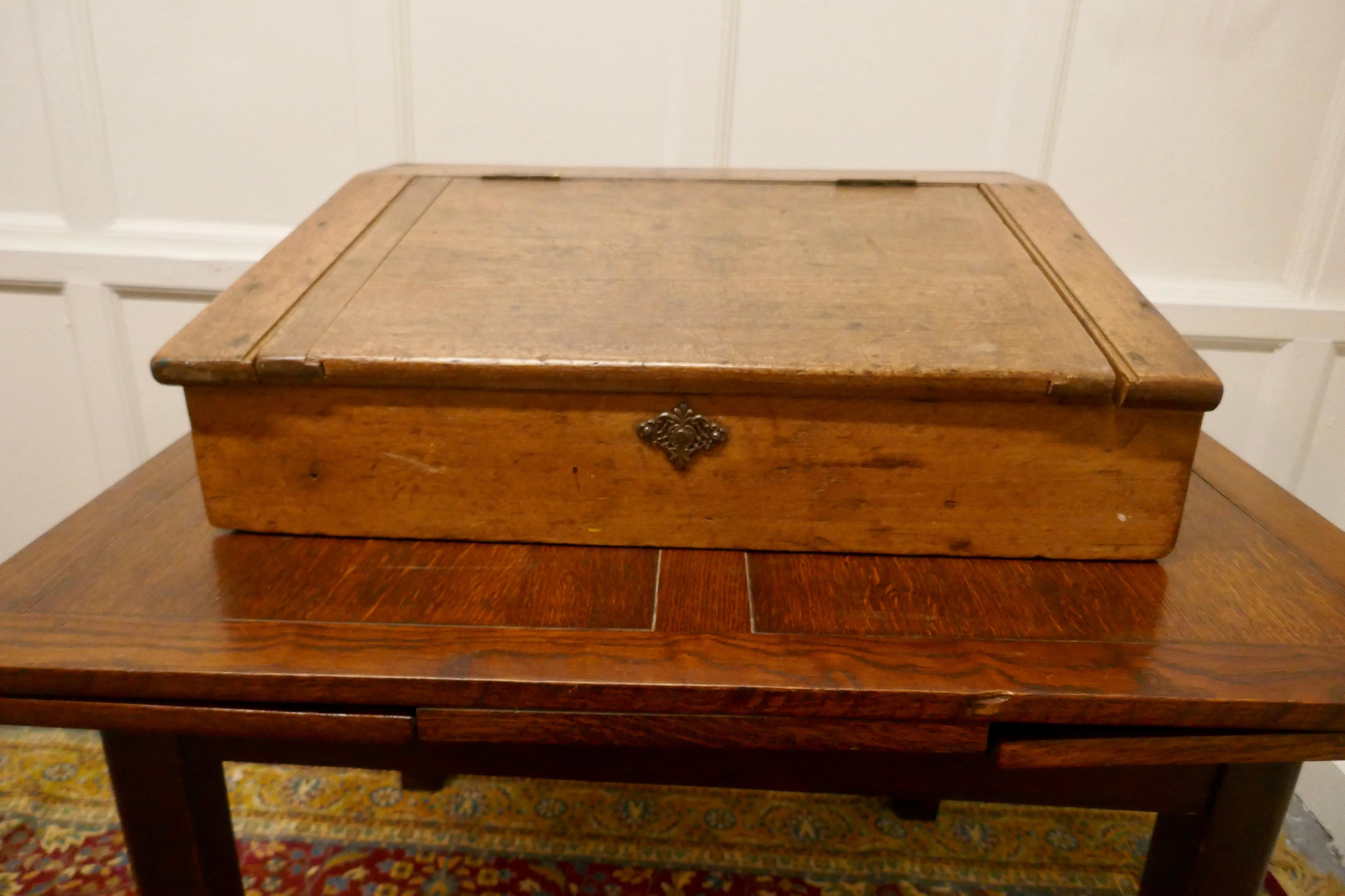 Antique pine sloping clerks writing desk 

A Lovely old piece, the desk is made in solid pine, it has a sloping lid which encloses a storage compartment
A lovely old piece in its original natural pine finish
The desk is 8.5” high, 27” wide and