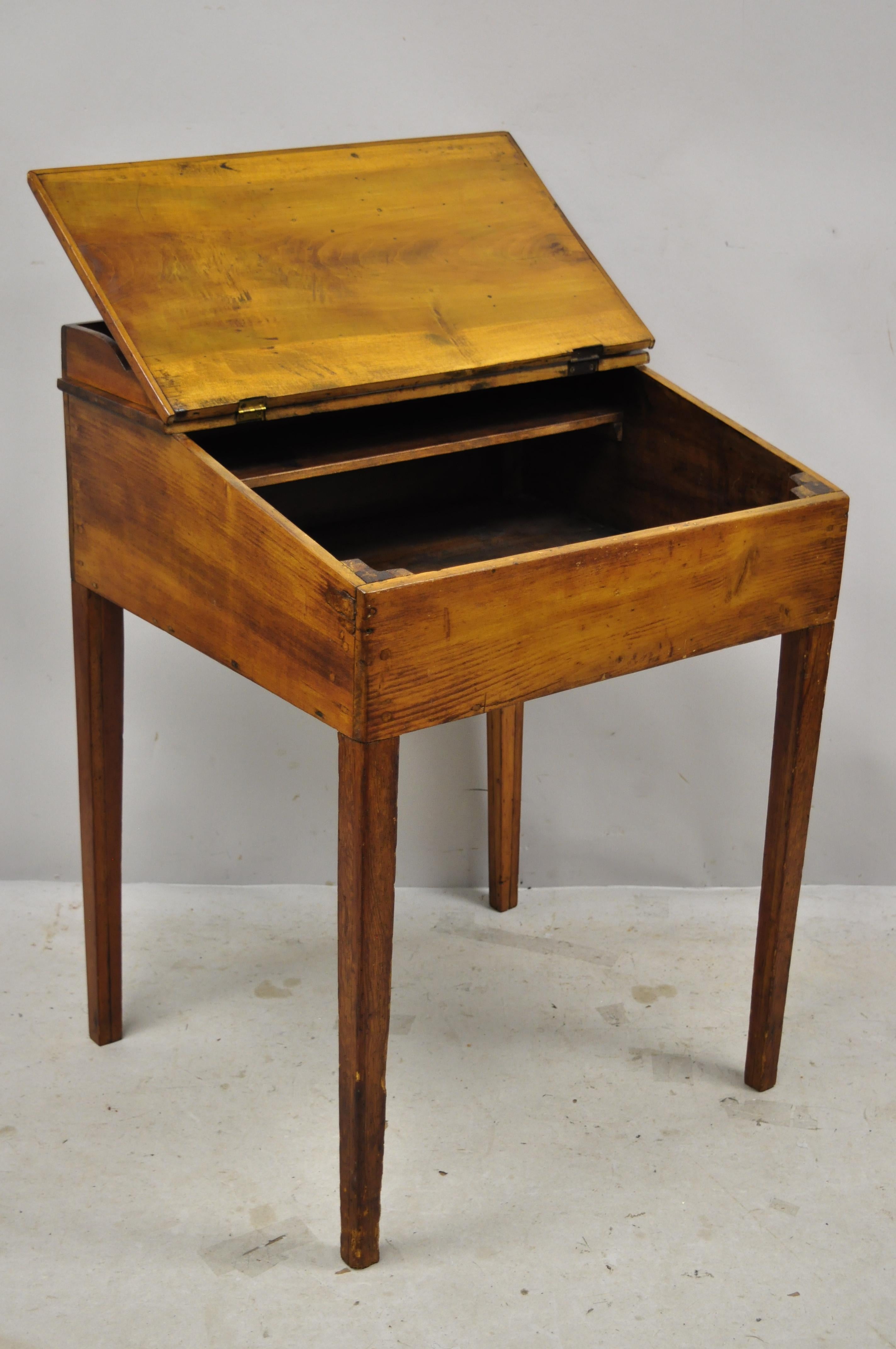 Antique pine wood American primitive flip storage work plantation desk table. Item features desirable aged patina, lift top with storage, tapered legs, very nice antique plantation desk, great style and form, circa 19th century. Measurements: 35