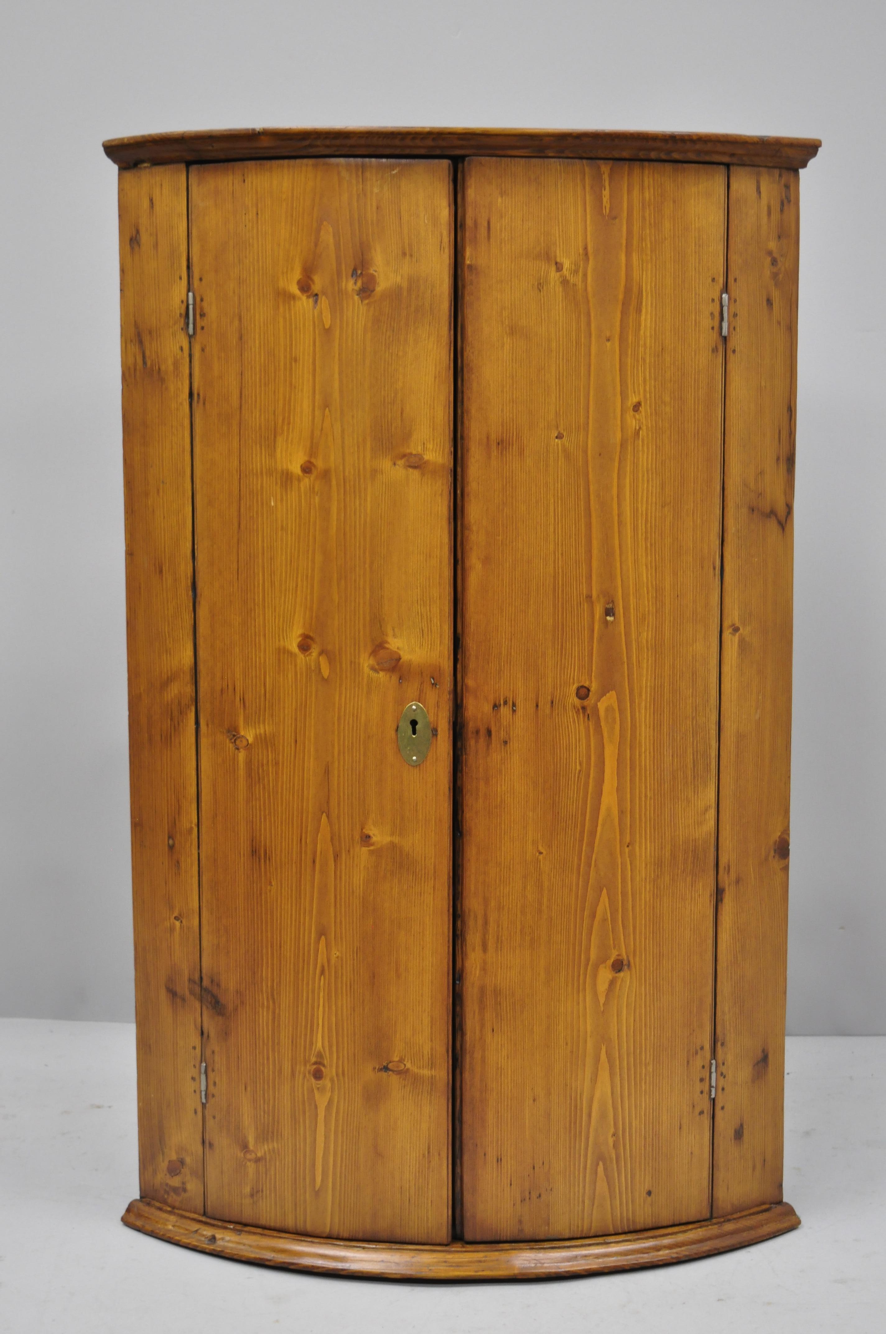 Antique pinewood wall hanging corner cabinet cupboard with blue painted interior. Item features blue painted interior, solid wood construction, beautiful wood grain, 2 swing doors, no key but unlocked, 2 wooden shelves, quality American