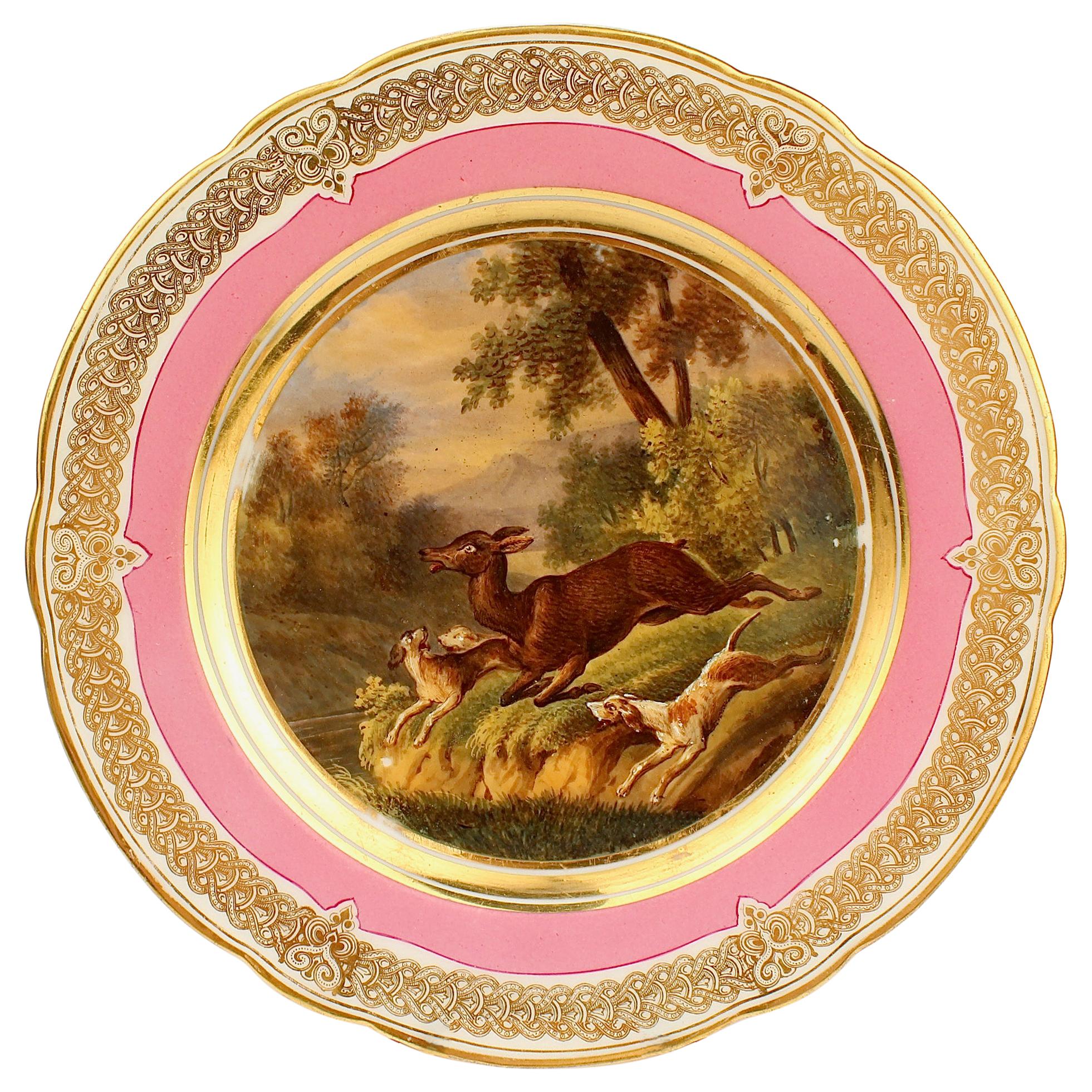 Ancienne assiette en porcelaine de Paris à bordure rose, peinte à la main, représentant une chasse au cerf et un chien