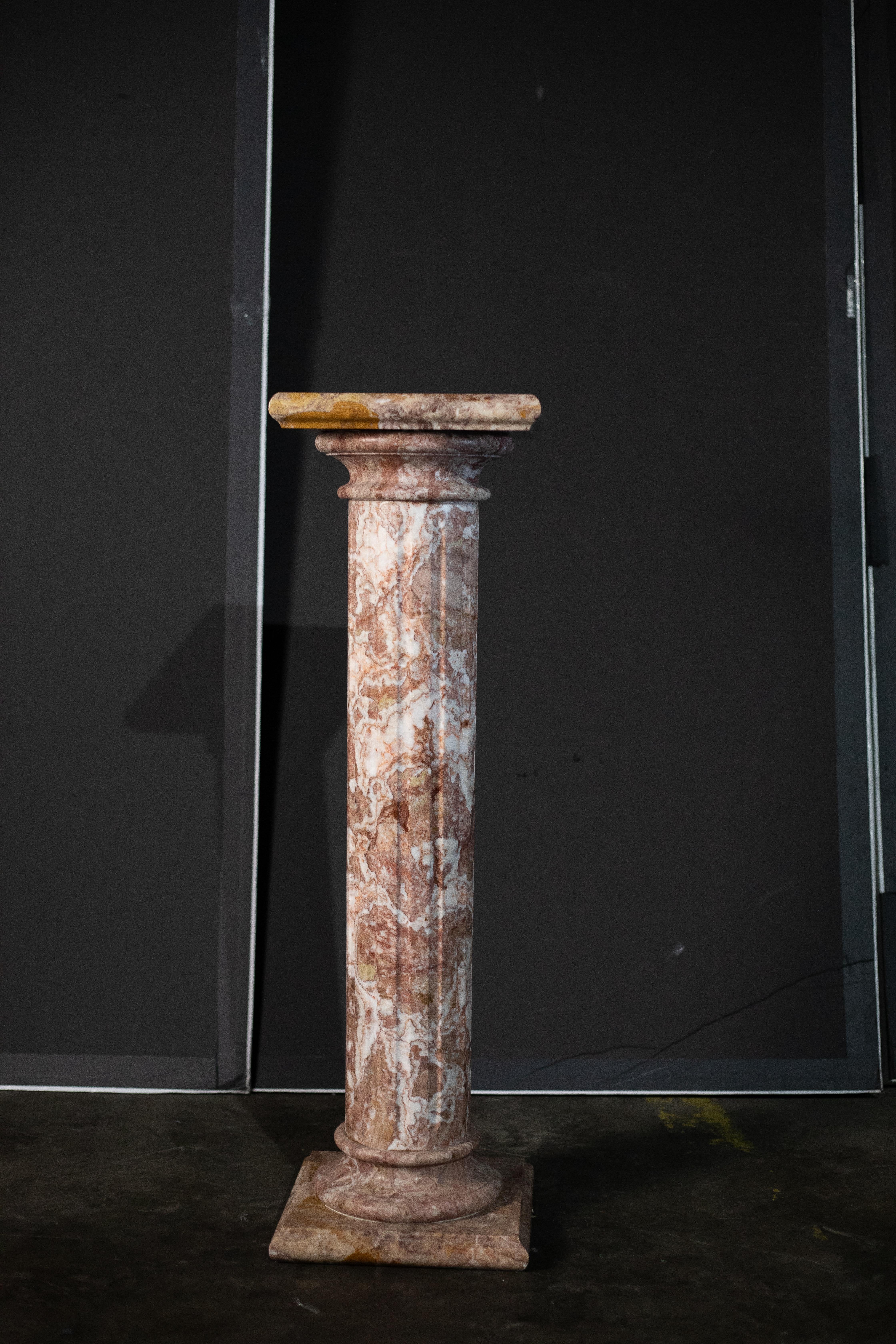 Elegant antique marble pedestal carved in a classical Tuscan style, dating from the late 19th to early 20th century. The column is executed in richly variegated pink Breccia marble, displaying beautiful natural veining in warm tones of rose, ivory,