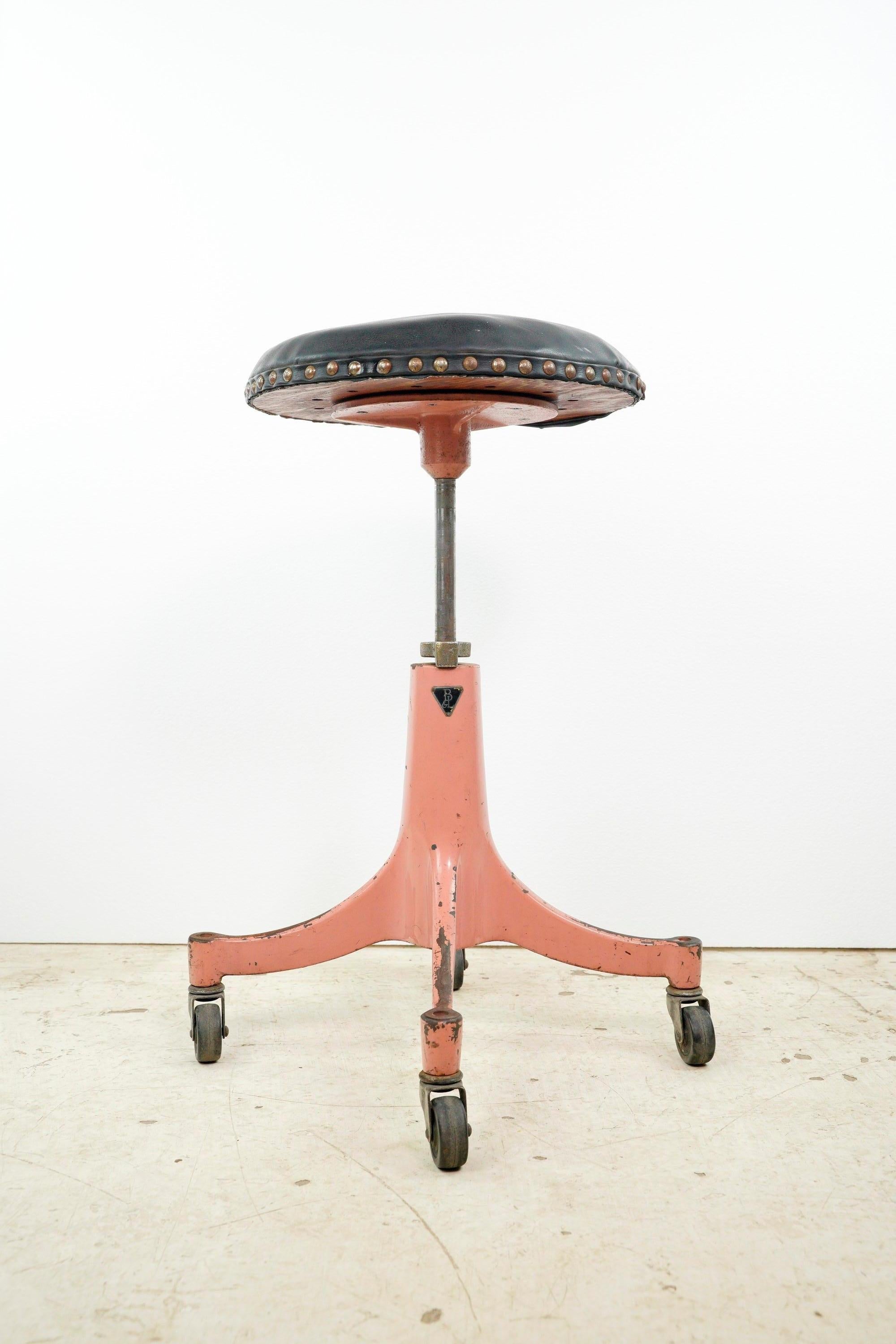 Antique pink cast iron base adjustable black leather stool combines elegance and functionality. With its charming design and adjustable height, it offers a stylish seating option for various spaces with a touch of vintage flair. This is in fair