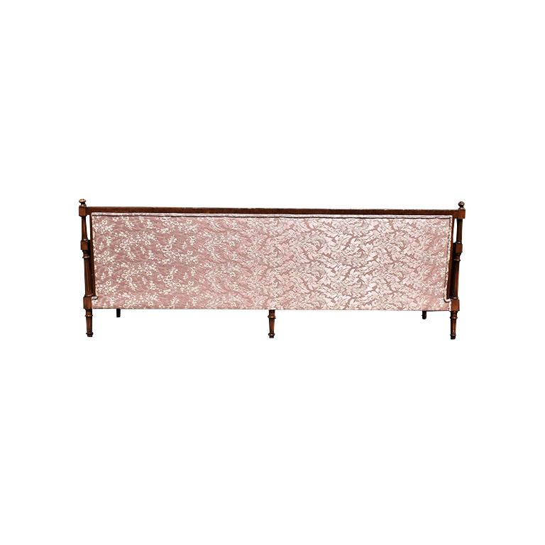 An exquisite light pink silk sofa with hand-carved wood decoration. This piece will be perfect in a living room, or even used as a daybed. This sofa seats four and features four removable bottom cushions, and four waterfall shape back cushions. Two