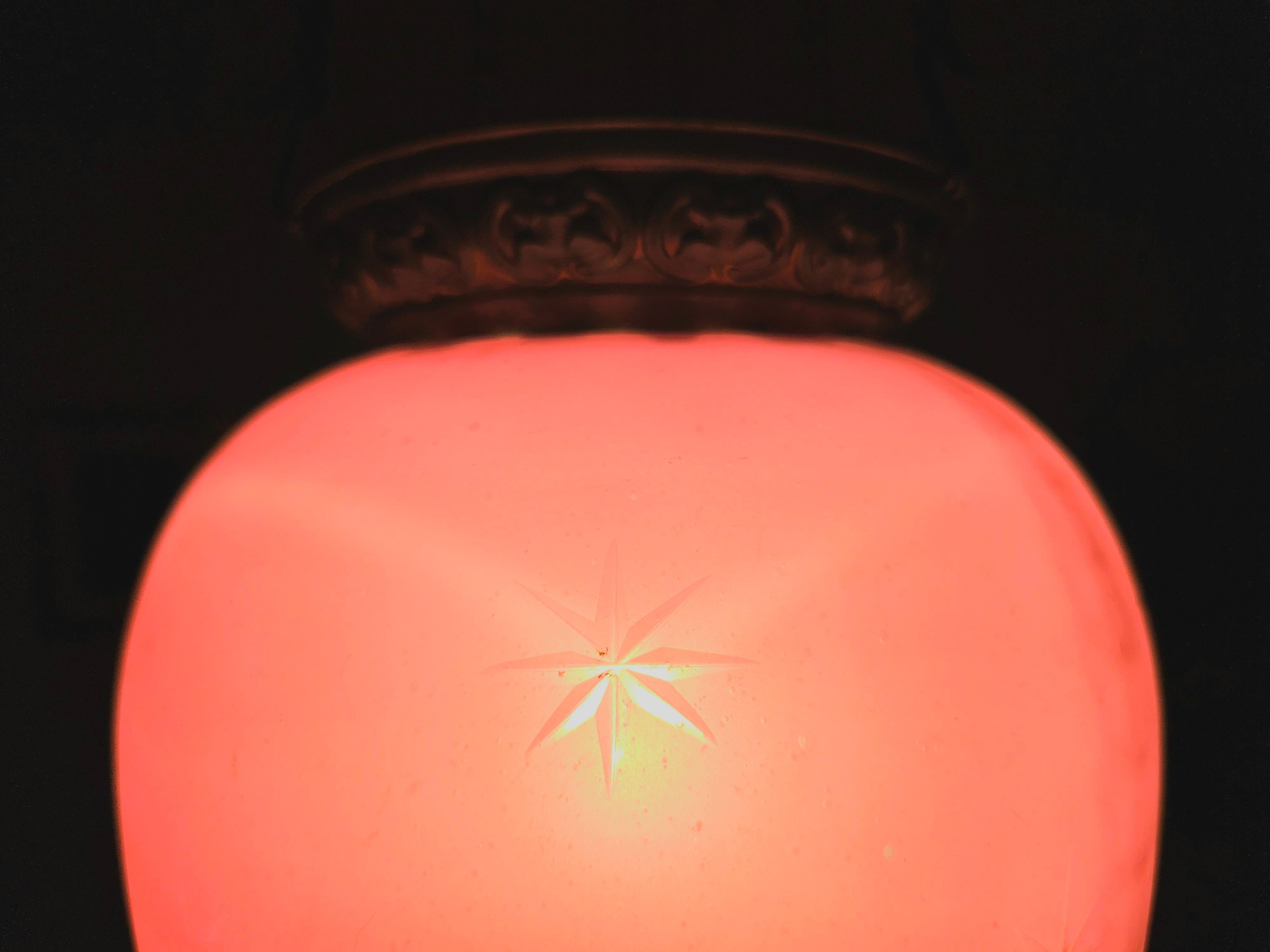 Dans cette annonce, vous trouverez une lanterne en verre rose antique extrêmement décorative, avec des éléments décoratifs en laiton. Le verre lui-même est orné d'étoiles taillées. Il évoque l'esprit romantique du Biedermeier viennois et s'intègre