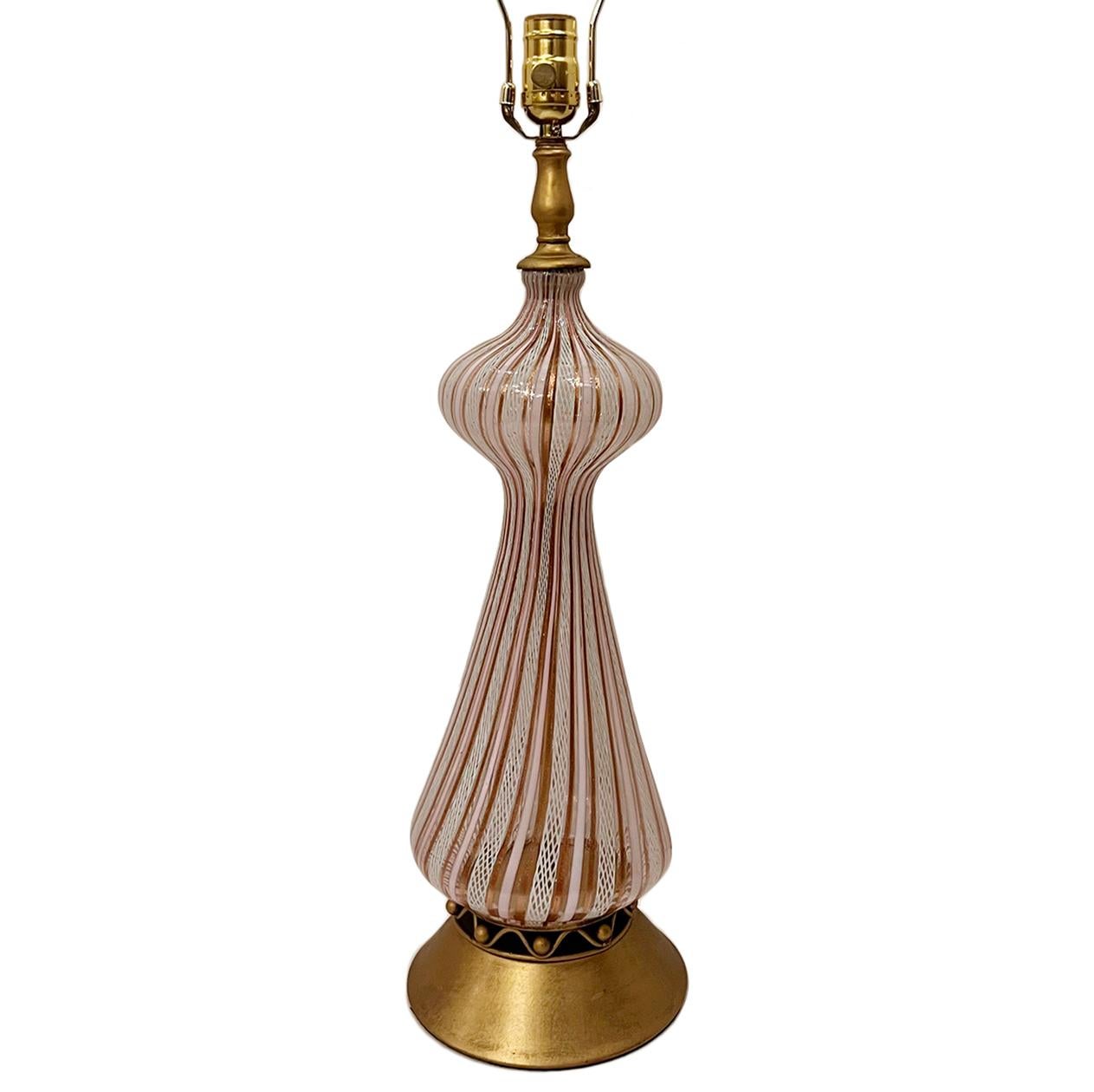 Lampe de table en verre soufflé d'origine italienne, datant des années 1920, avec base dorée.

Mesures :
Hauteur du corps : 21
Hauteur de l'abat-jour à l'appui : 31