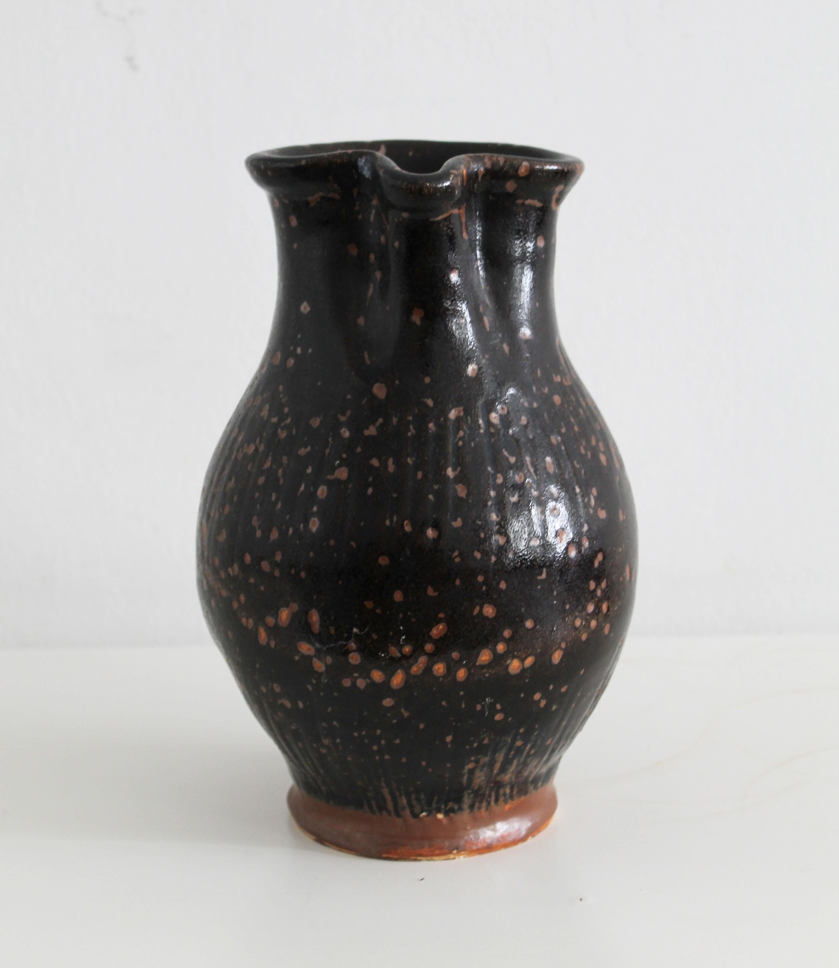 Cast Antique pitcher made of dark glazed stoneware For Sale