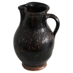 Antique pitcher made of dark glazed stoneware