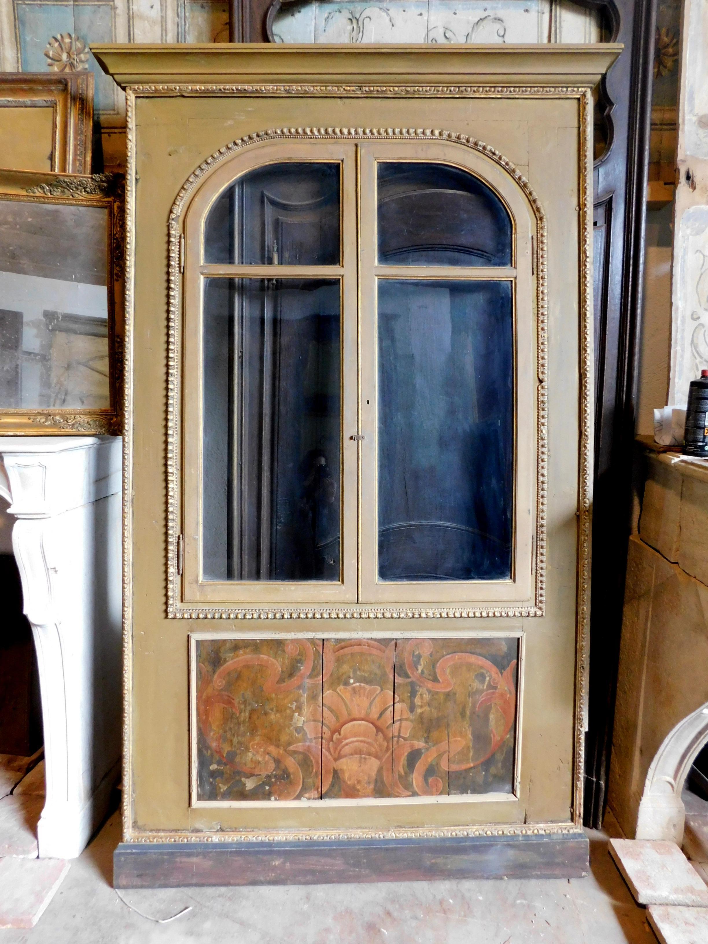 Antikes Plakat, Einbauschrank, Schrankfront in der Wand, aus Massivholz, geschnitzt und lackiert mit Glastüren im oberen Teil und bemalter Platte als Sockel, handgefertigt und handbemalt in der Mitte des 19. Jahrhunderts in Italien.
Der obere Teil