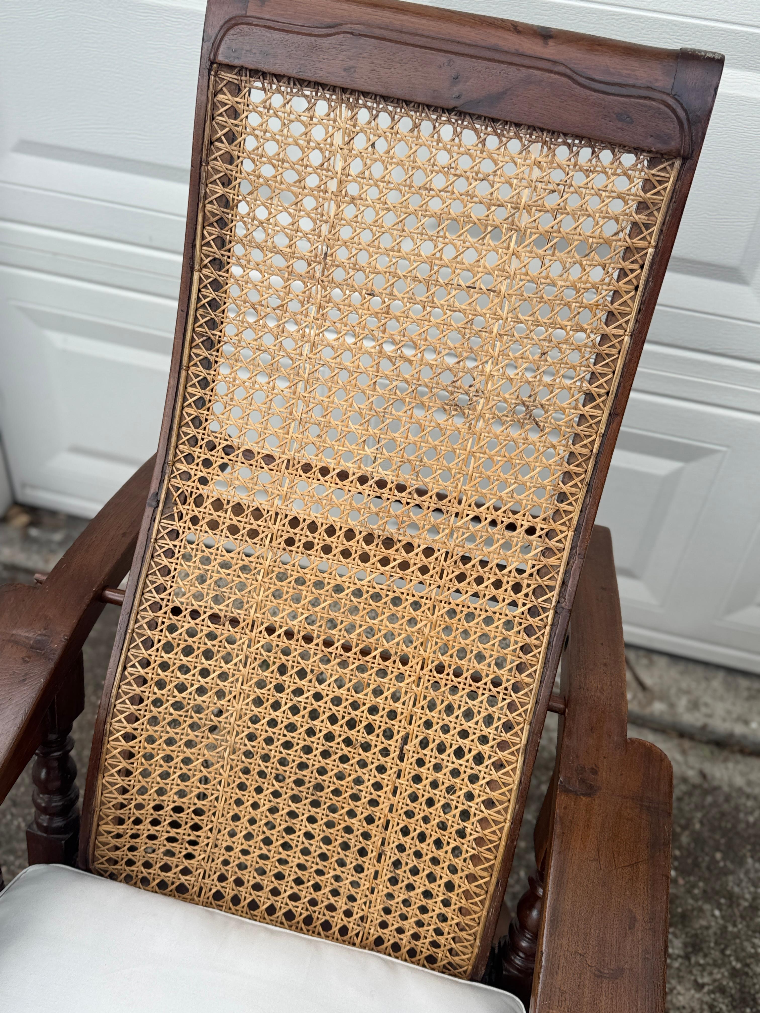 European Antique plantation chair with handwoven cane and fold out footrests, circa 1920S For Sale