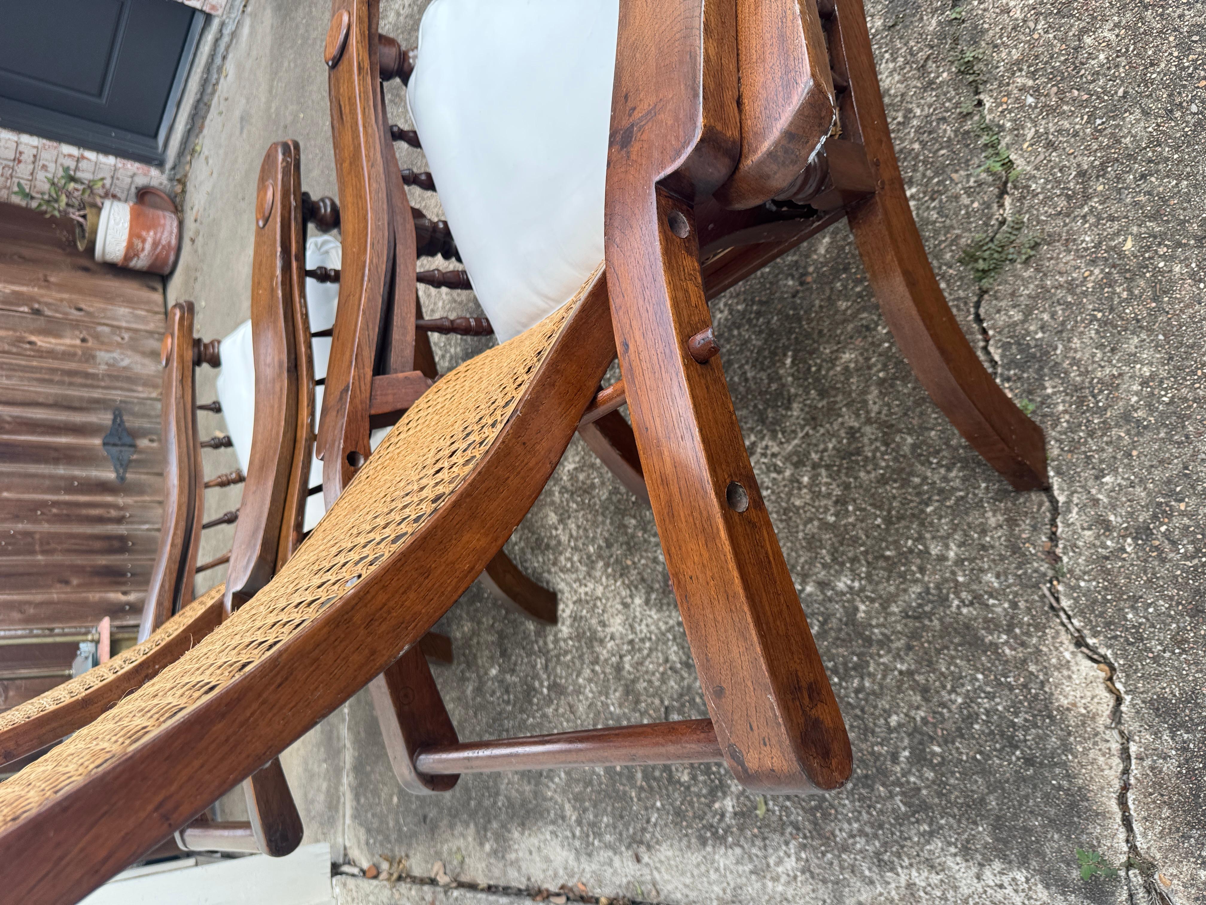 Teak Antique plantation chair with handwoven cane and fold out footrests, circa 1920S For Sale