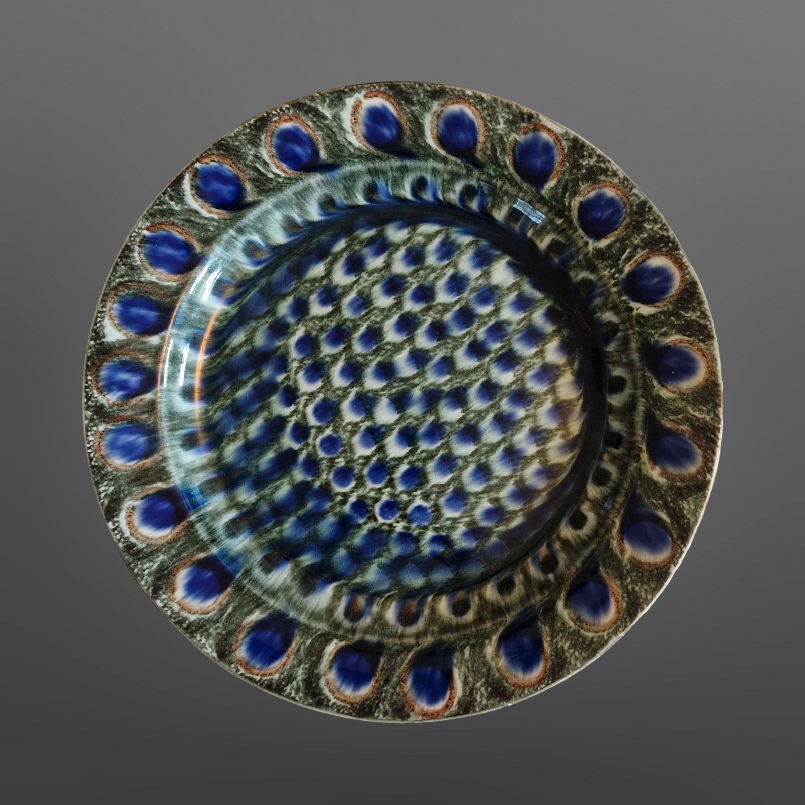 Very rare decorative plate. Made by Freidrich Festeresen between 1909 and 1916. It has a peacock pattern which appears to have flowed out to much on one side. This outflow gives it an almost psychedelic appearance. Beside the works by Festersen are