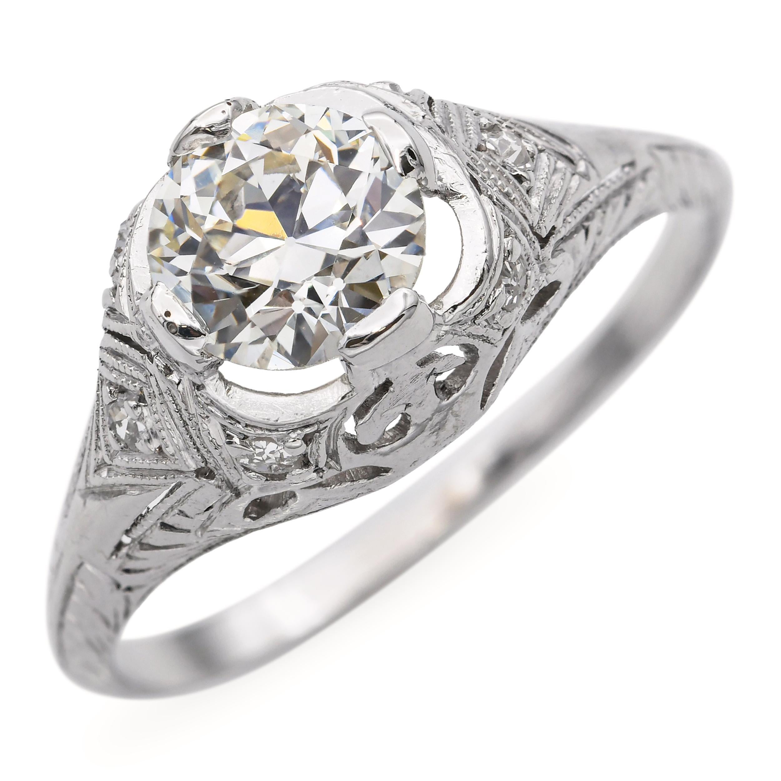 Cette élégante bague de fiançailles ancienne est fabriquée en platine et comporte un diamant de 0,91 carat, de couleur L et de pureté SI1. La pierre centrale est mise en valeur dans une monture intemporelle qui souligne sa douce chaleur et son
