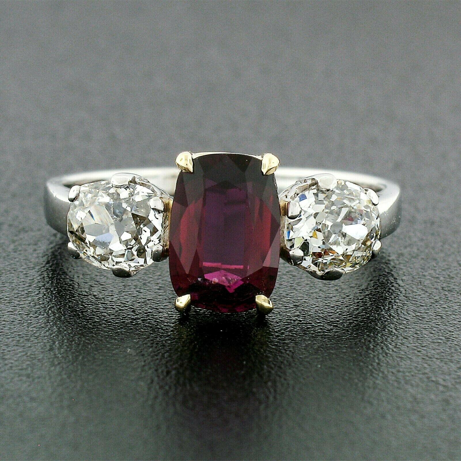 You're looking at a truly breathtaking antique 3-stone ring that was crafted from solid .900 platinum and 14k yellow gold during the art deco period. The center stone is a 1.64 carat, GIA certified, natural ruby with no indications of heating. The