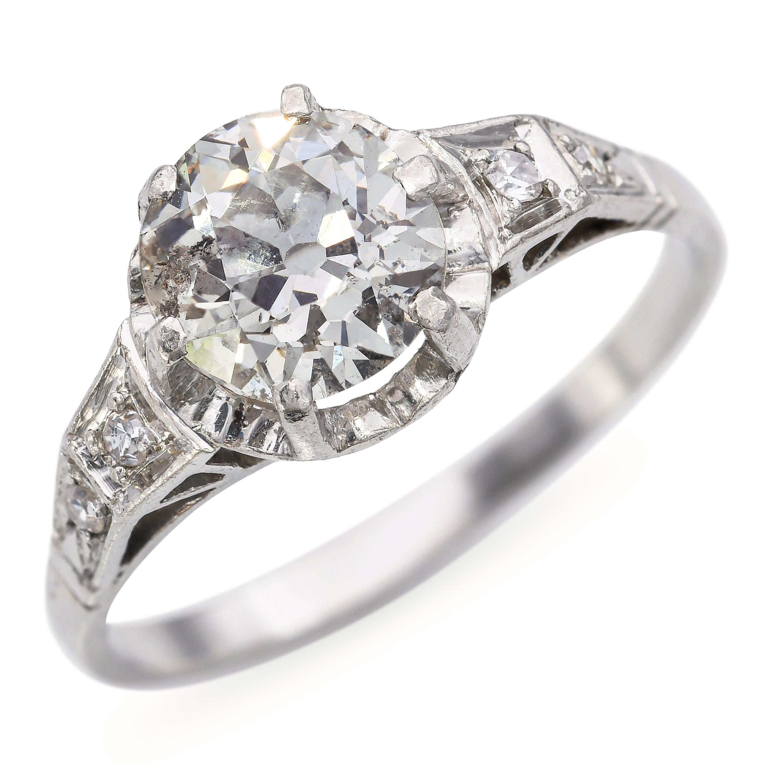 Este elegante anillo de compromiso antiguo está elaborado en lujoso platino y luce 1,57 quilates totales de brillantes diamantes. El diseño presenta un brillante diamante central complementado por piedras acentuadas cuidadosamente engastadas,