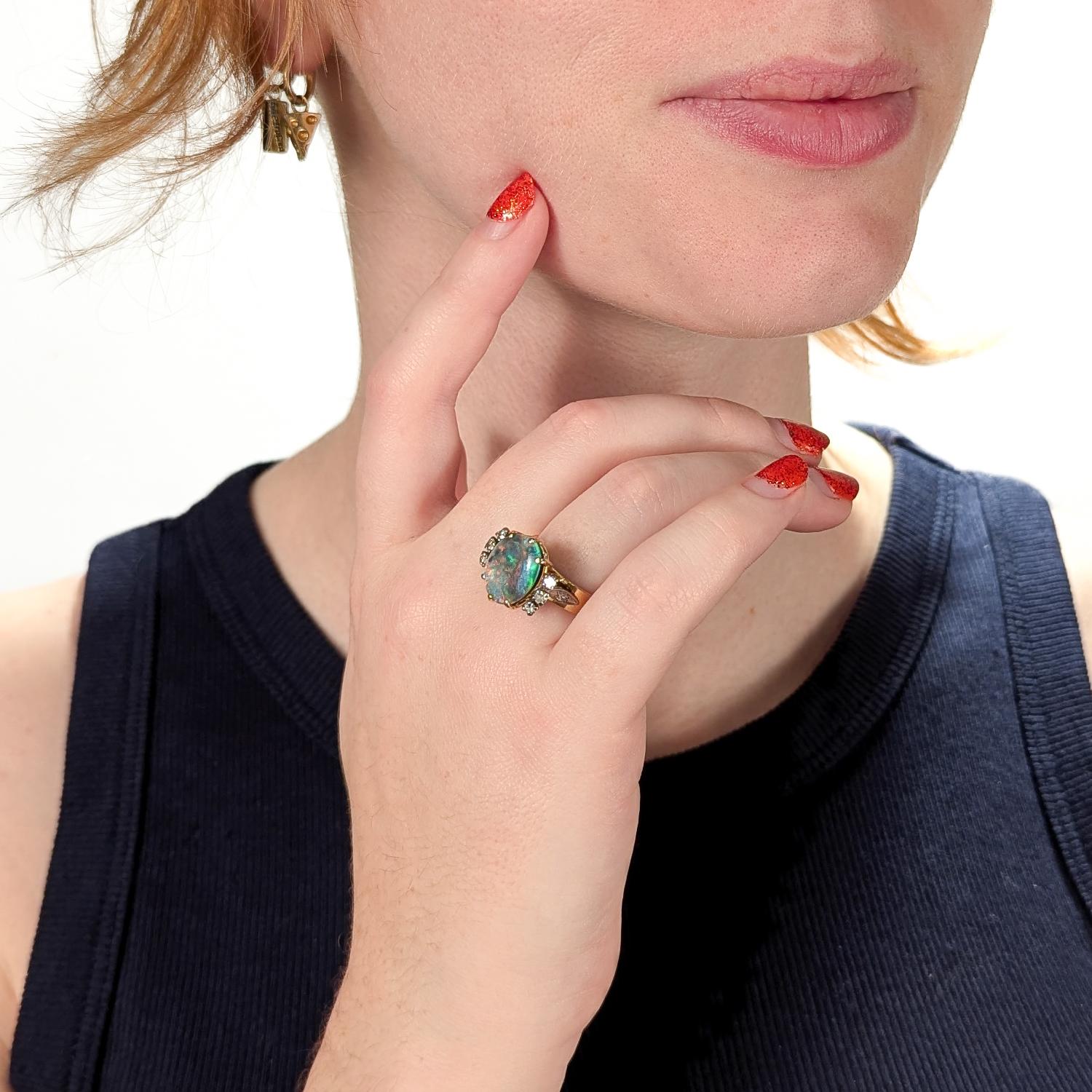 A fine antique platinum, gold, opal & diamond ring.

In platinum & 18 karat yellow gold.

With a basket-set 3.35± ct black opal (transparency: semi-translucent, color hue: black w/ green, blue, & yellow, saturation: strong) oval cabochon surrounded