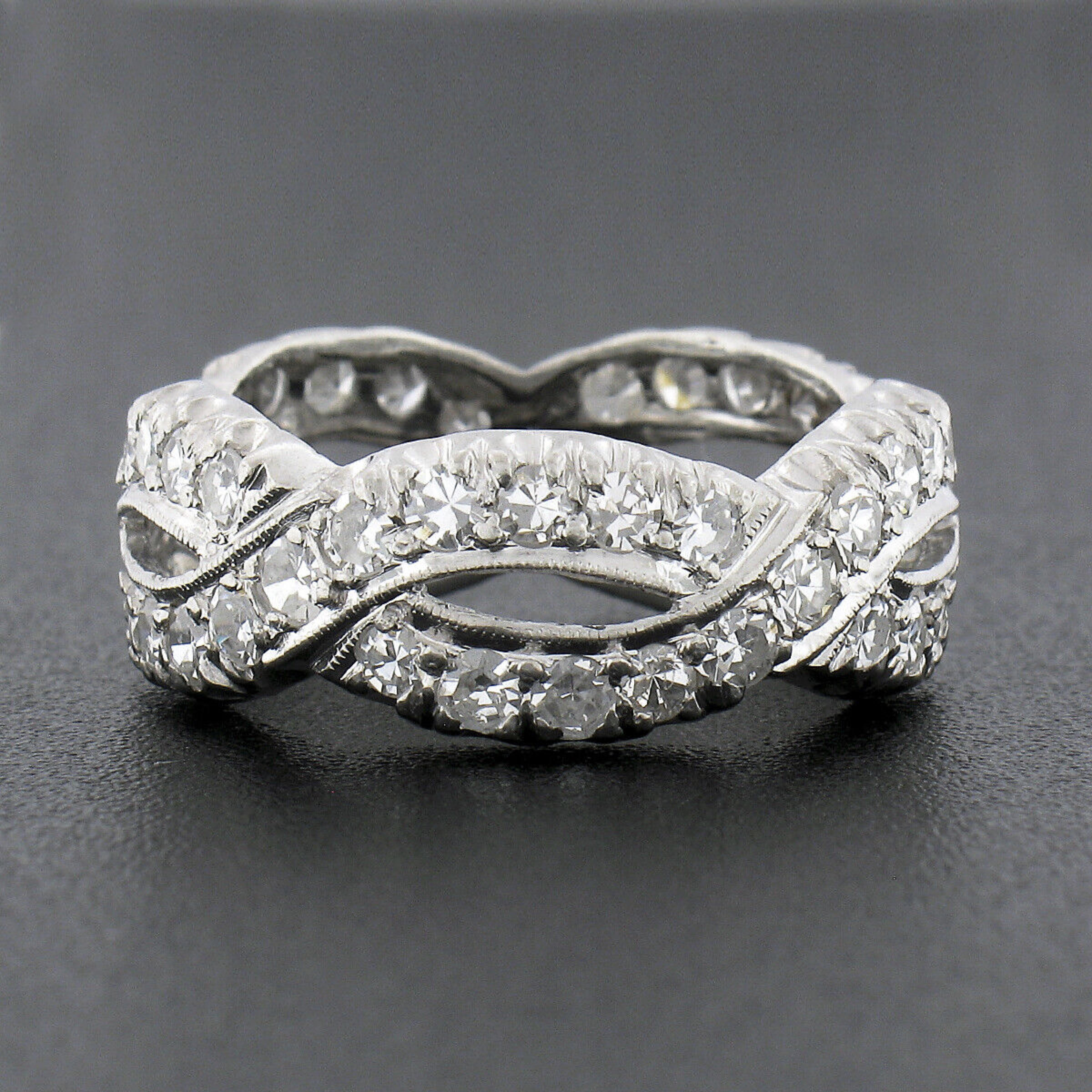 This truly breathtaking antique diamond eternity band ring was crafted during the 1940's from solid platinum and features an infinity braided design set with approximately 1.90 carats of fine quality diamonds neatly pave set throughout the entire