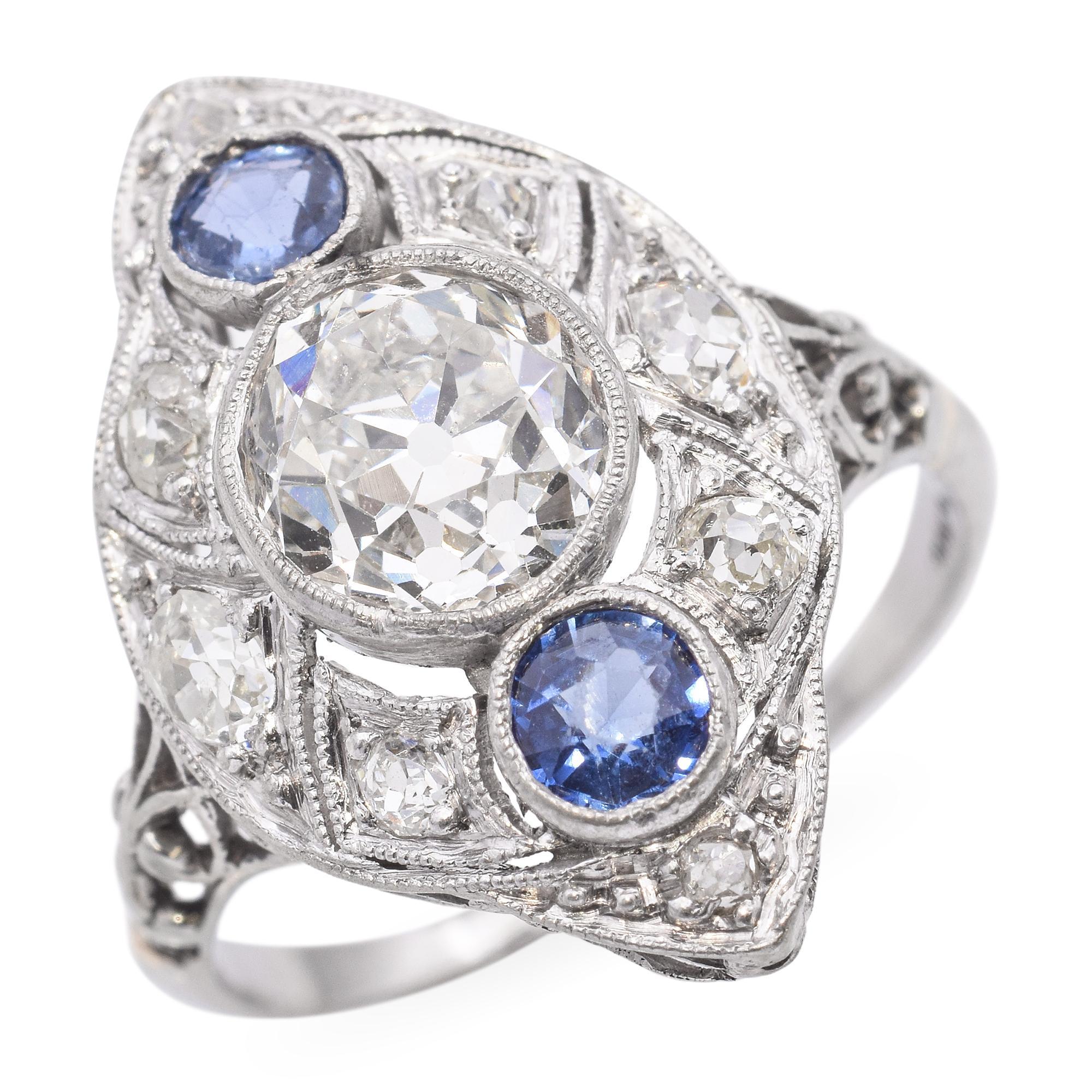 Cette bague de table ancienne en platine présente un éblouissant poids total de 2,0 carats de diamants accentués par de riches saphirs bleus. Le design élégant présente un travail complexe du métal et des détails vintage, mettant en valeur l'éclat