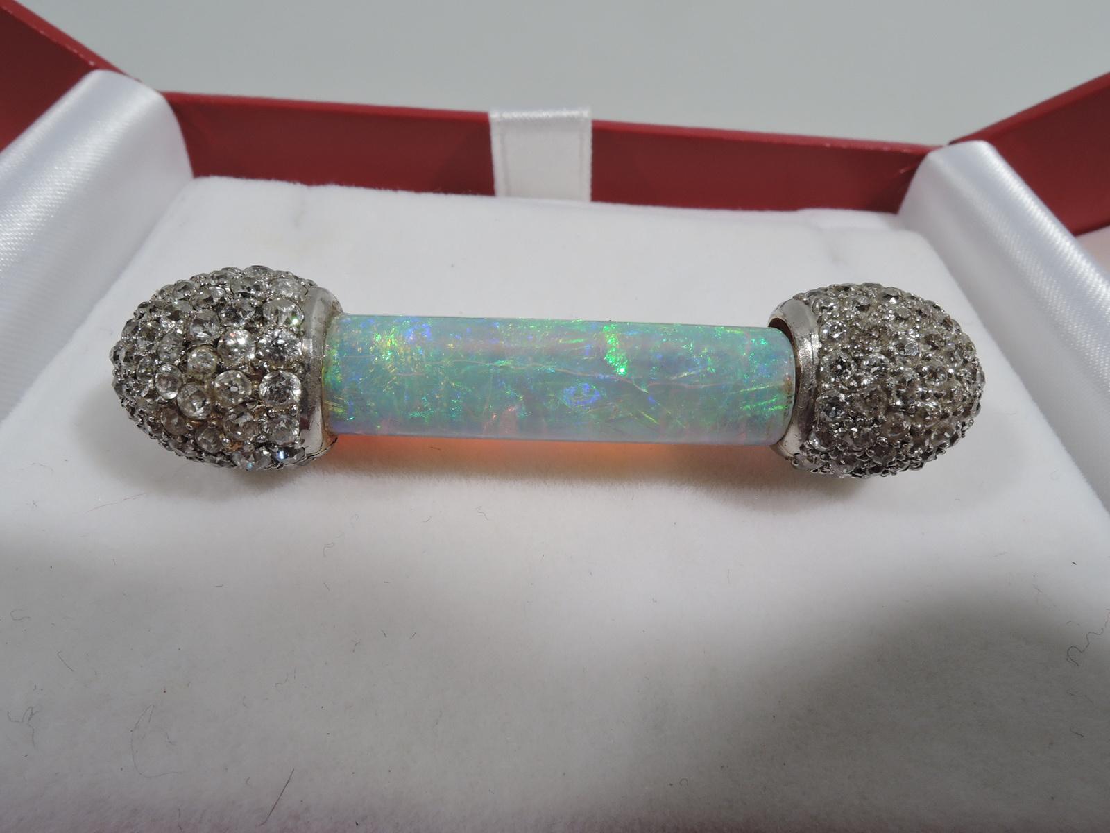 Stunning American Edwardian platinum brooch, ca 1900. Barbell form with cylindrical pipe opal. Ends encrusted with rose-cut diamonds.