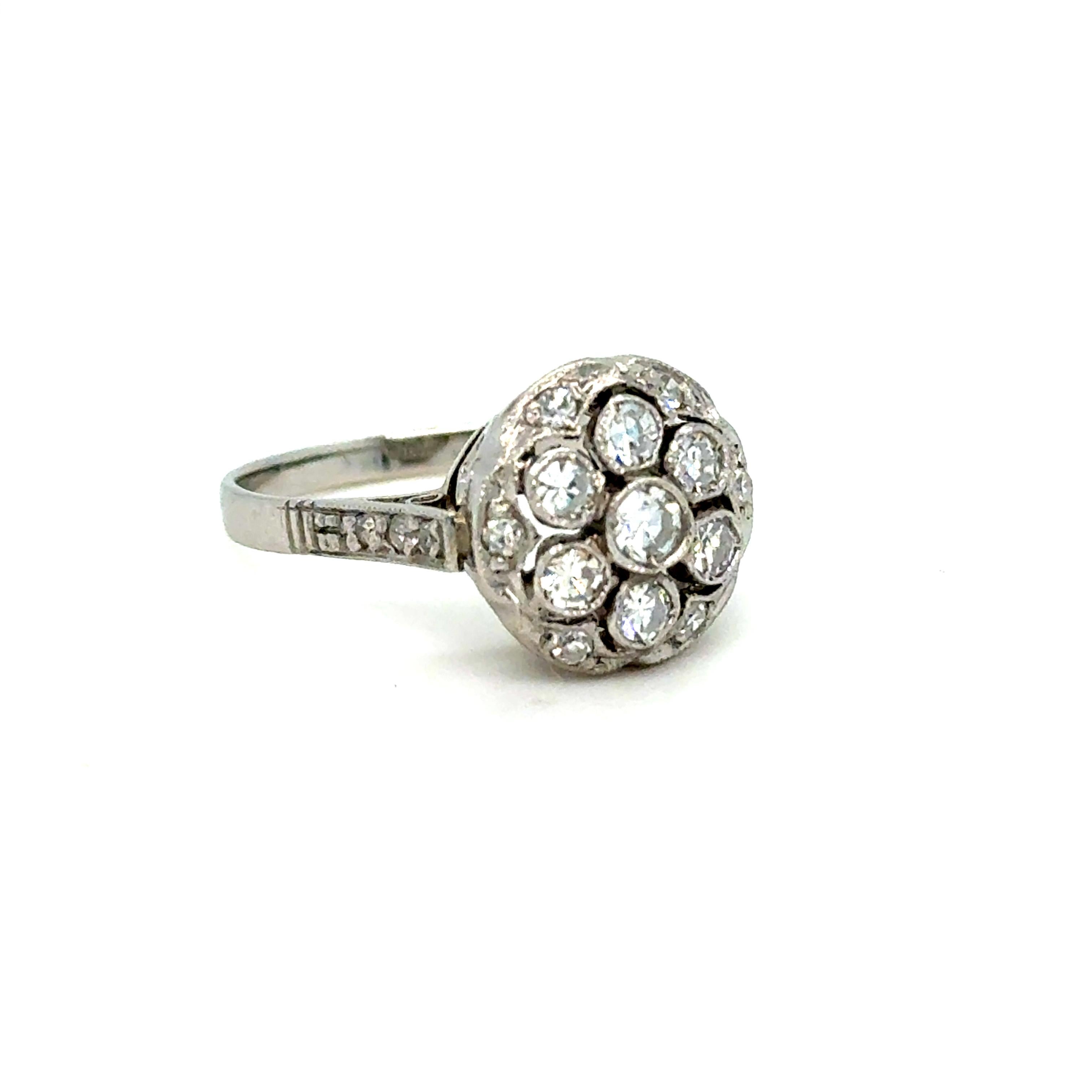 Fai un salto indietro nel tempo con questo anello antico a grappolo di diamanti mozzafiato, magistralmente realizzato in platino resistente. Al centro, una scintillante serie di diamanti brillanti forma un cluster luminoso, che irradia fascino