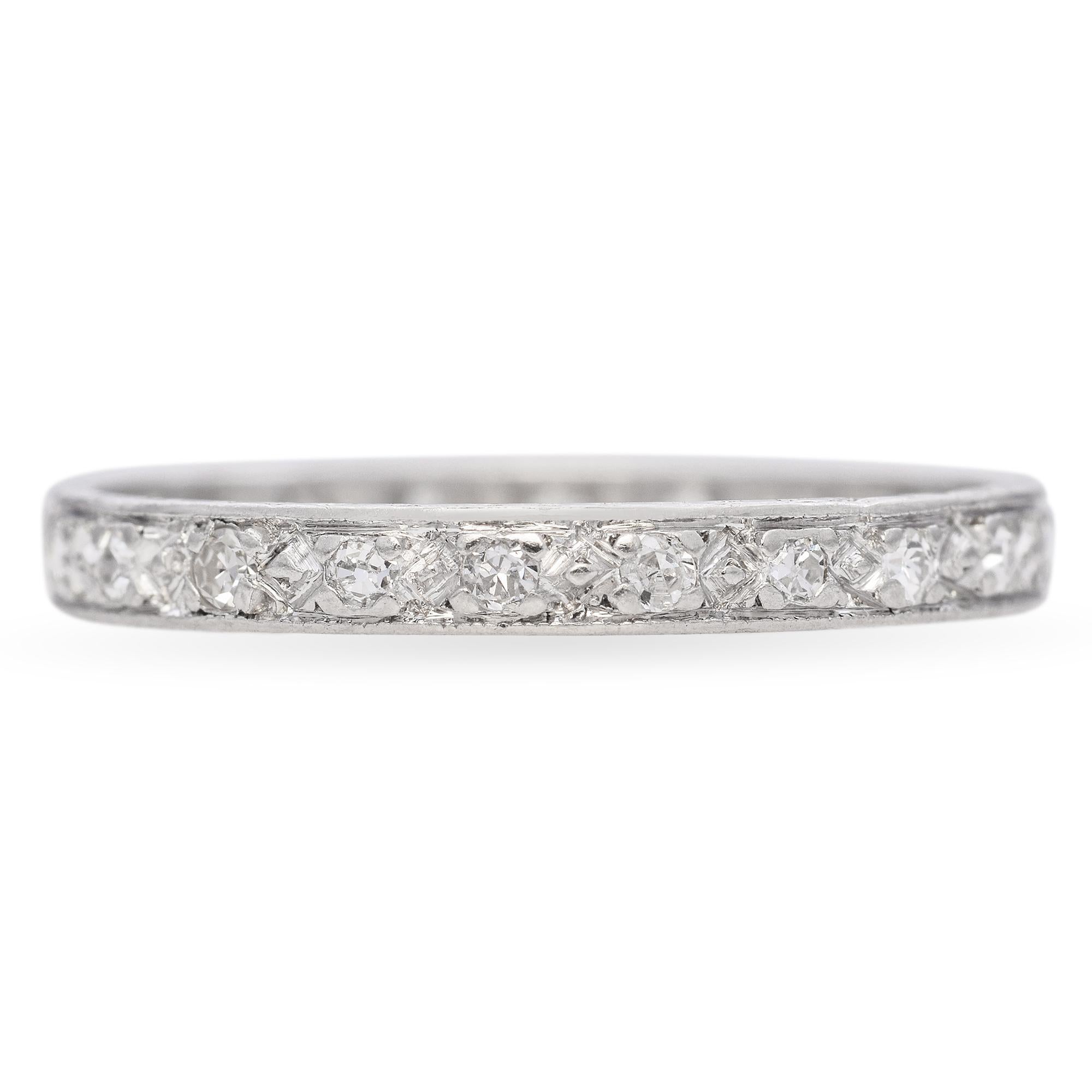 This antique diamond band is crafted in rich platinum, showcasing timeless elegance and enduring craftsmanship. Set with a row of sparkling diamonds, the design is both refined and understated, highlighting the brilliance of each stone. The platinum