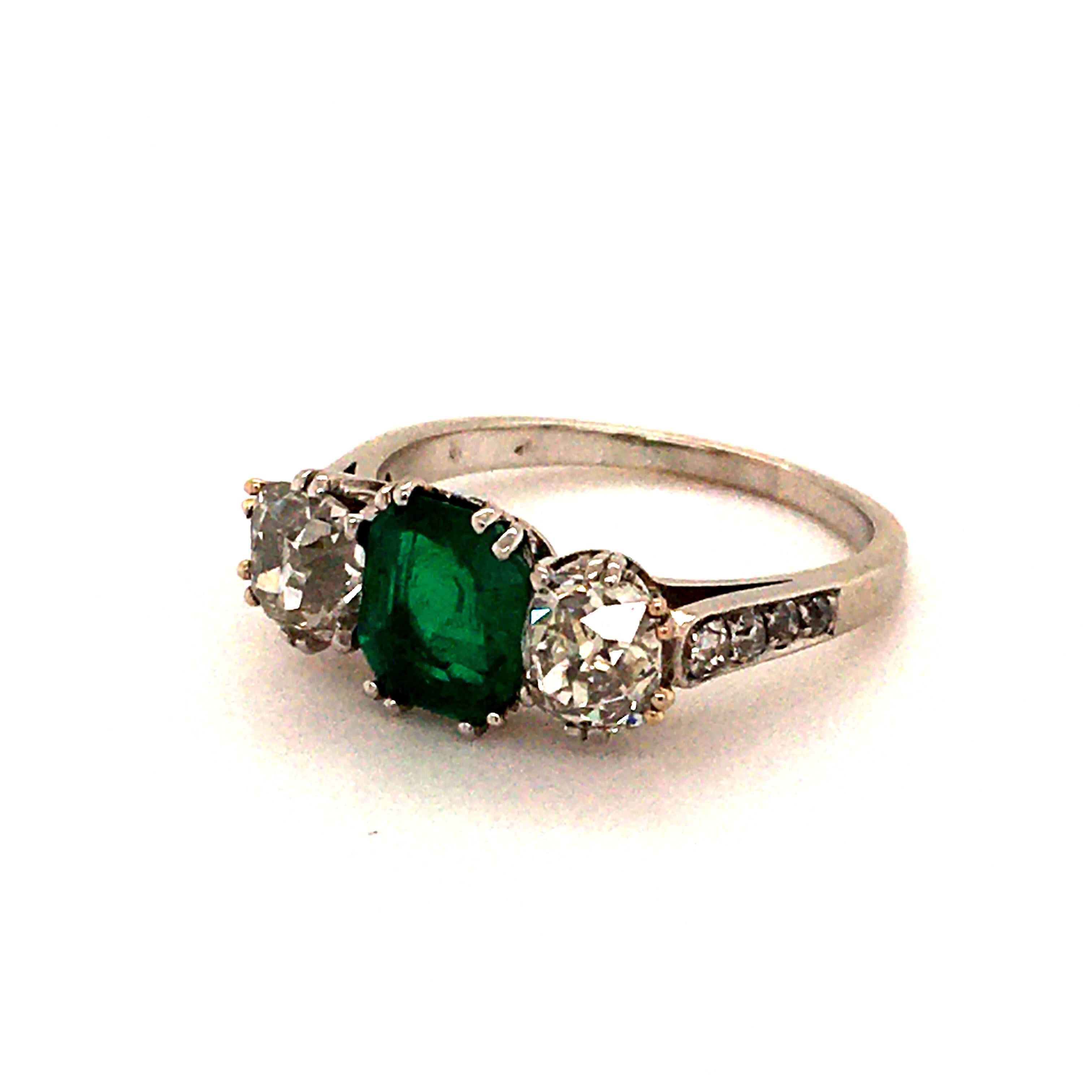 This antique stunner is made in platinum 950 and set with following stones:

1 emerald cut emerald of beautiful green colour approx. 1.40 ct, Colombian origin
2 old mine cut diamonds totaling approx. 1.30 ct of I/J-vs/si1 quality
8 old cut diamonds