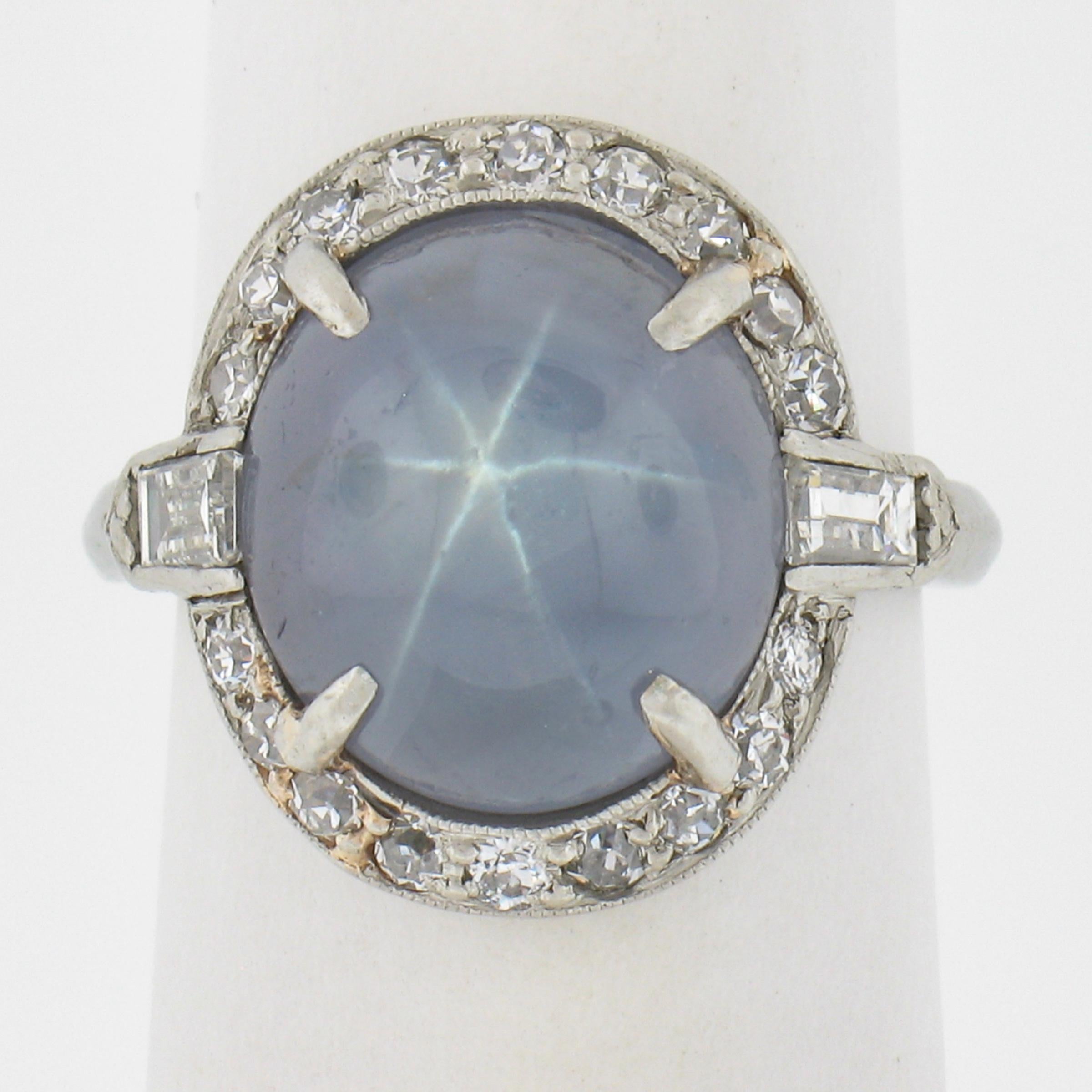 This gorgeous antique cocktail ring is crafted in solid platinum and features a gorgeous, GIA certified, natural star sapphire stone that displays a very clear and well centered star over its unique and desirable light blue color. The sapphire stone