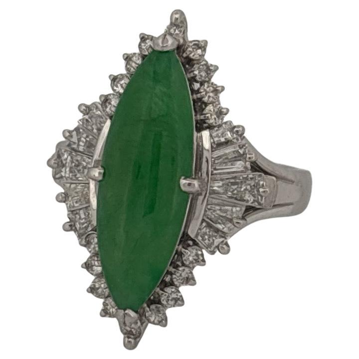 This striking platinum ring features an elongated marquise-shaped green jade as its centerpiece, exuding a serene and natural elegance. The vivid green jade is securely prong-set, drawing the eye with its smooth, polished surface and captivating